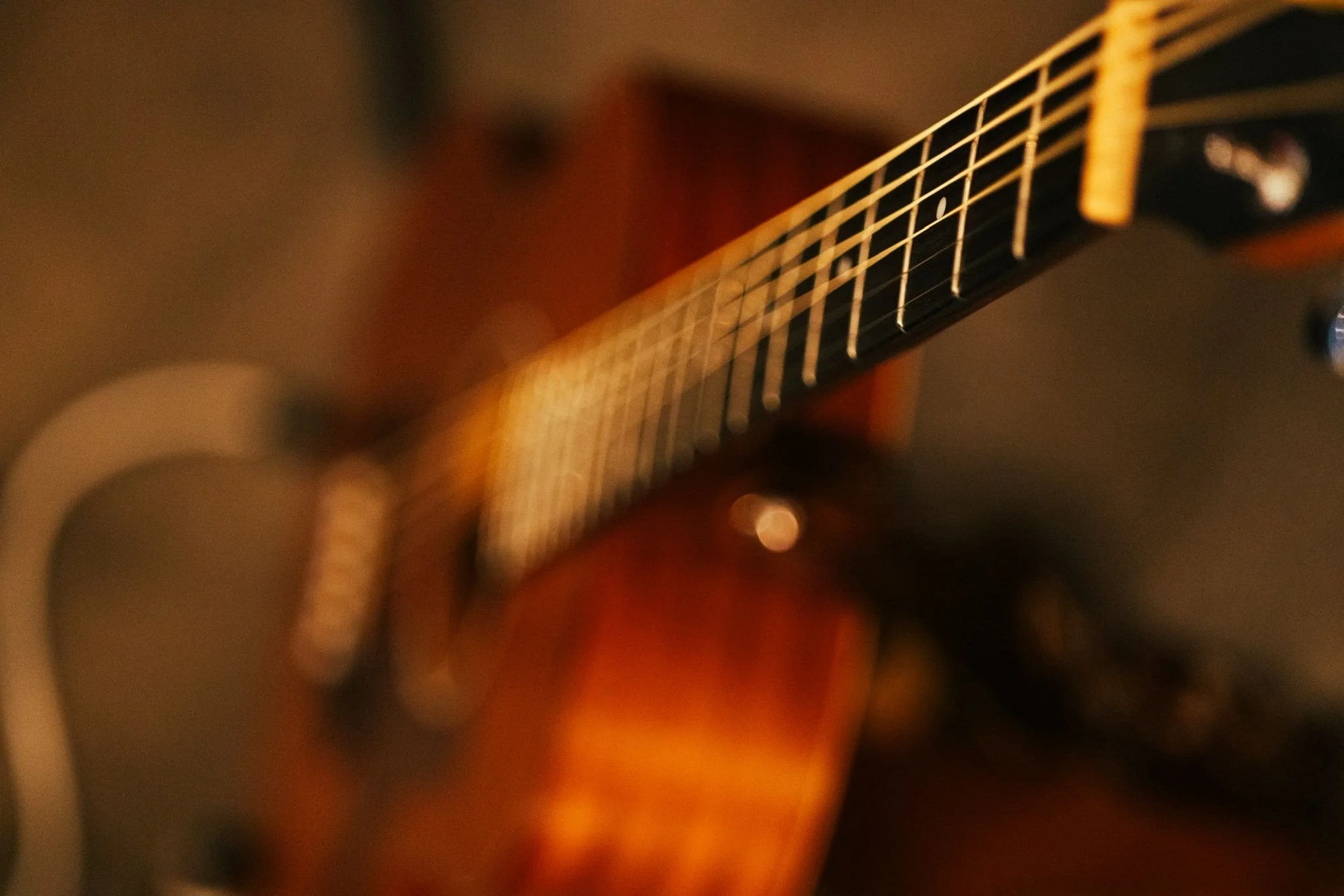 Close-up of acoustic guitar during a Louise Parker country pop live gig in Essex, capturing warm stage lighting and intimate live music atmosphere