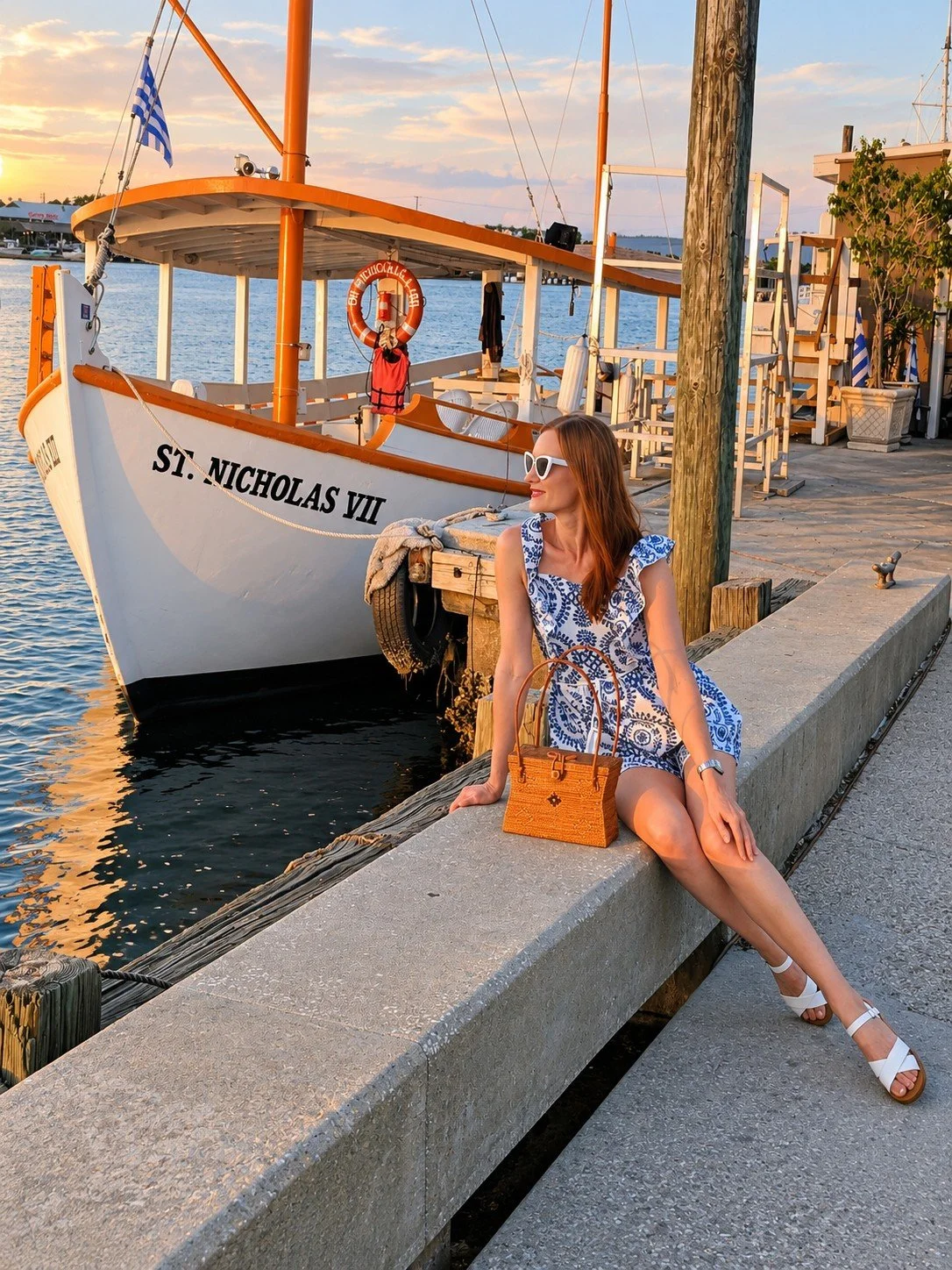 Woman posing with the Coastal Charm statement woven purse by the marina