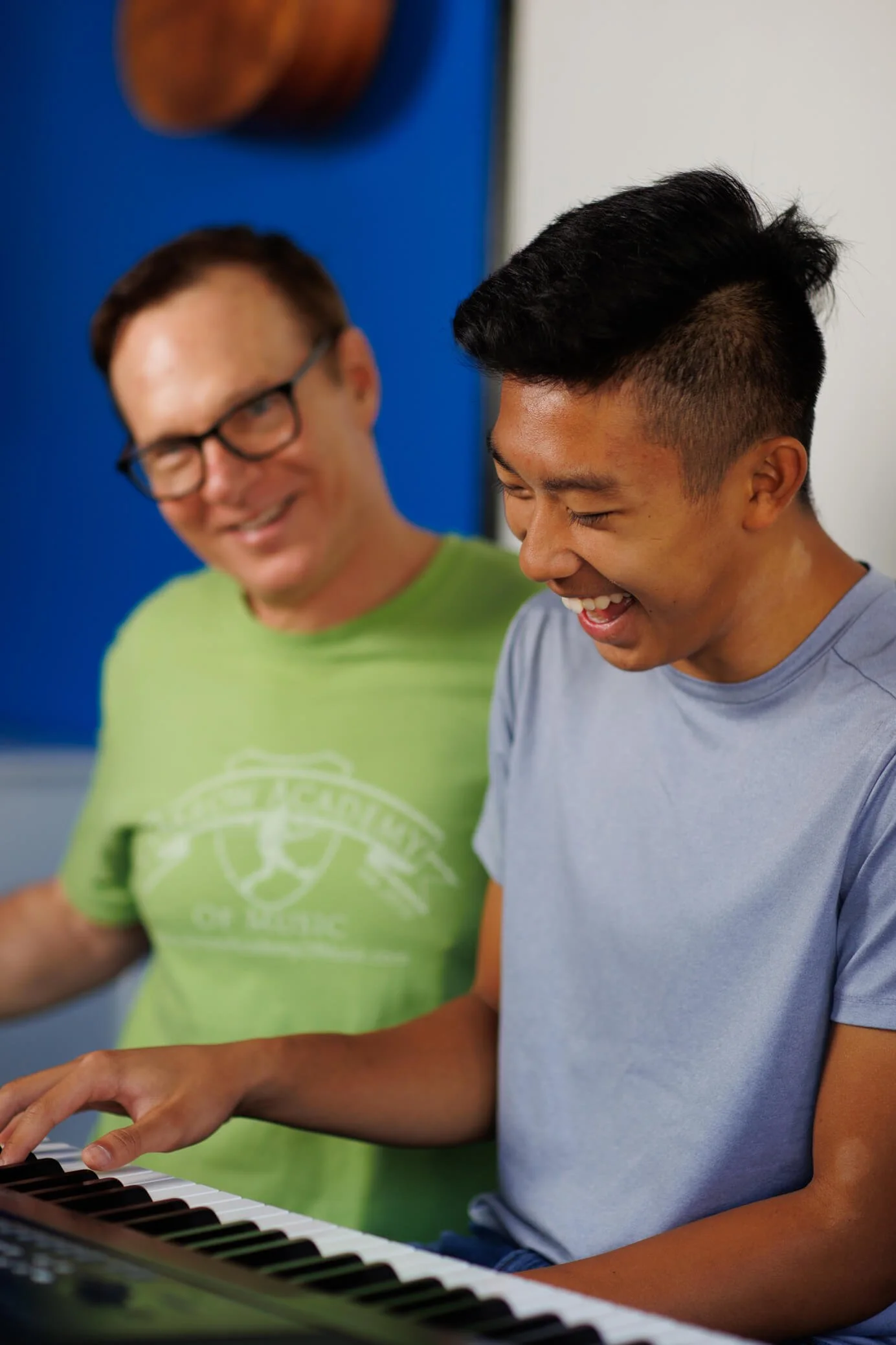 music teacher and teen at piano in studio