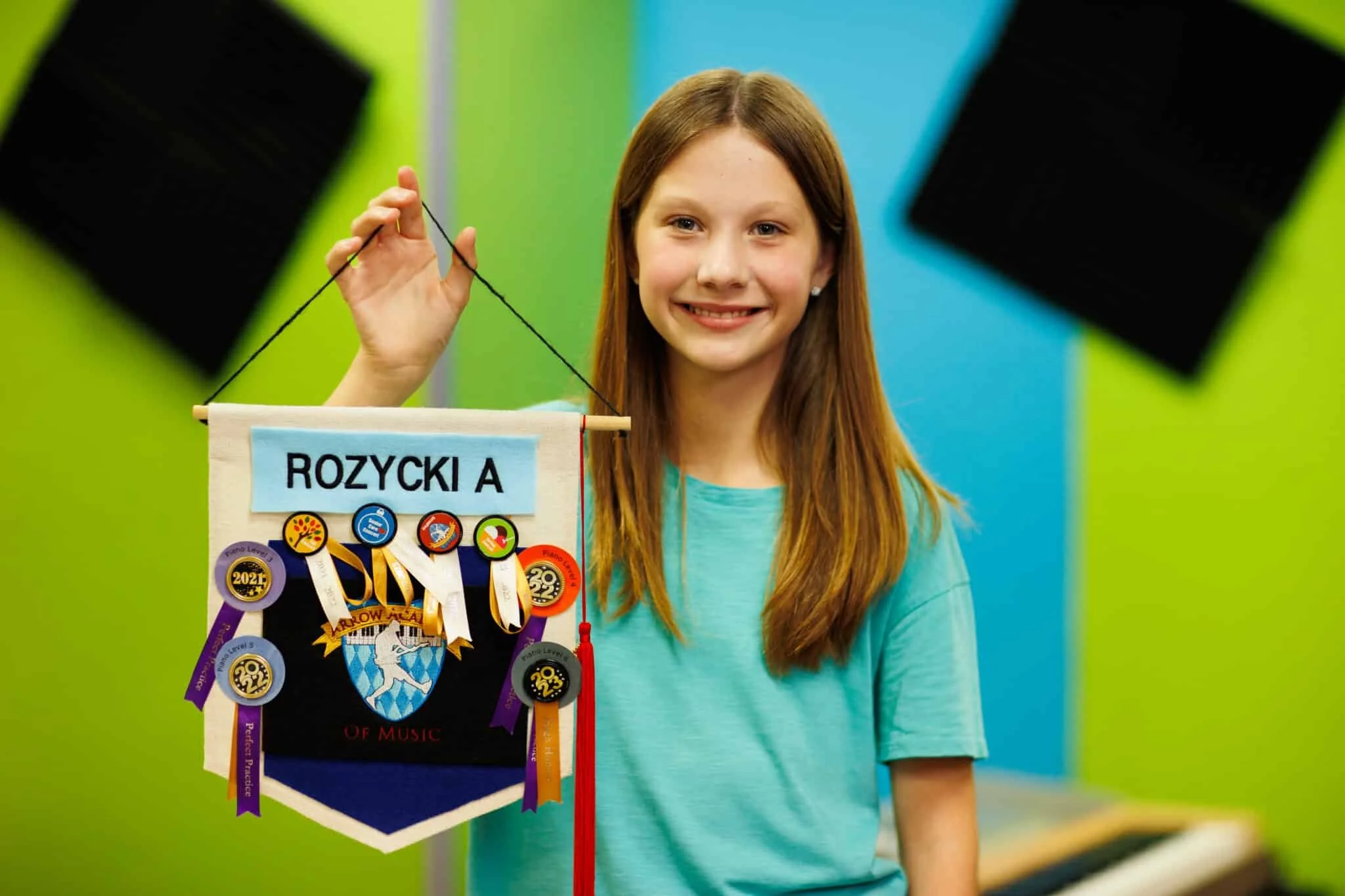 young teen student holding awards banner with ribbons