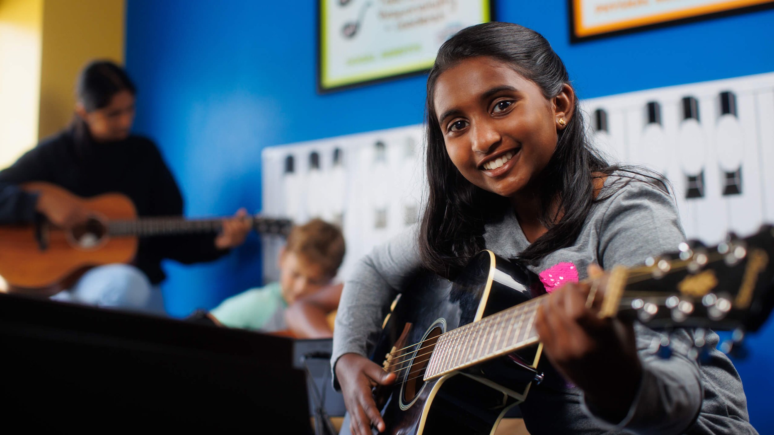 teen girl in guitar class at arrow academy of music