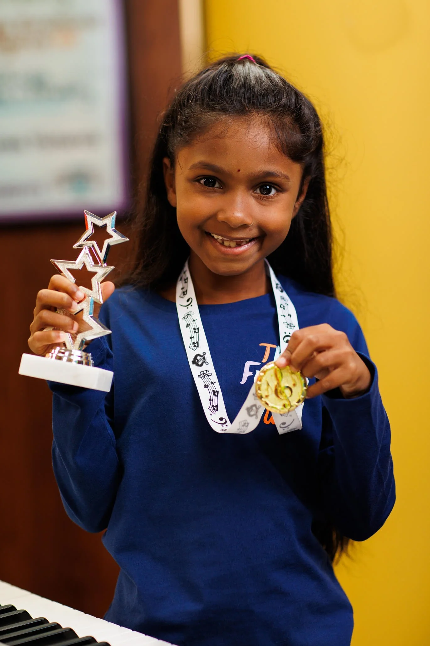 young girl holding medal and trophy