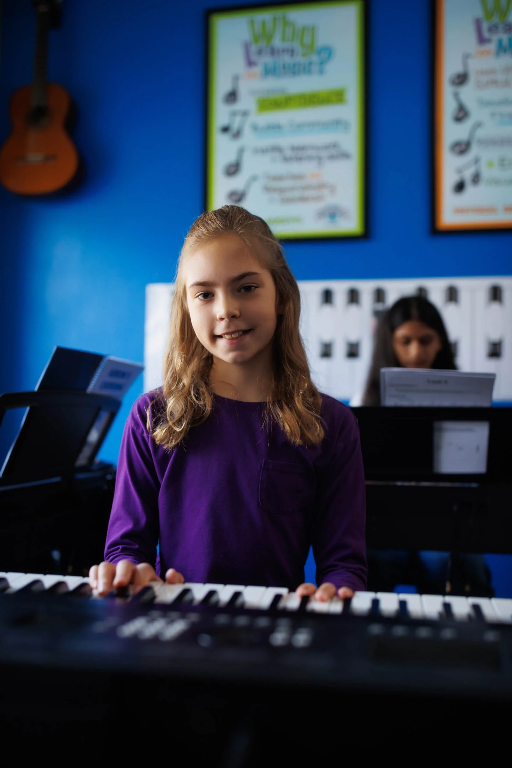 teen piano students in class at keyboards playing together