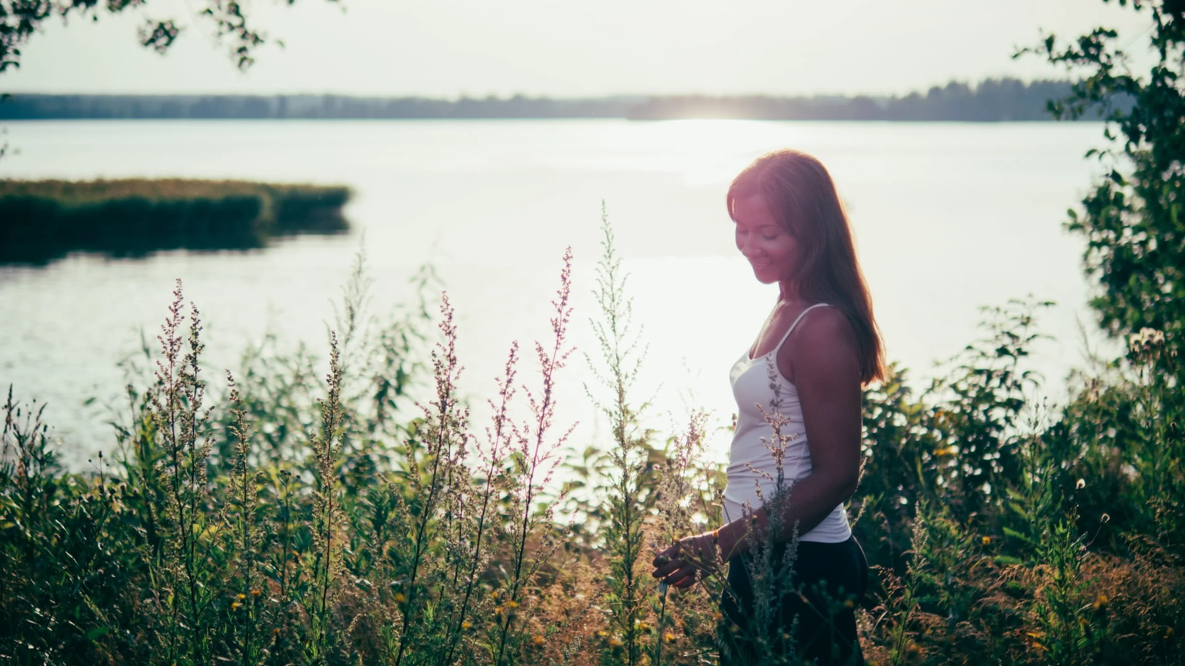 Hyvinvointiohjaaja luonnossa heinien keskellä
