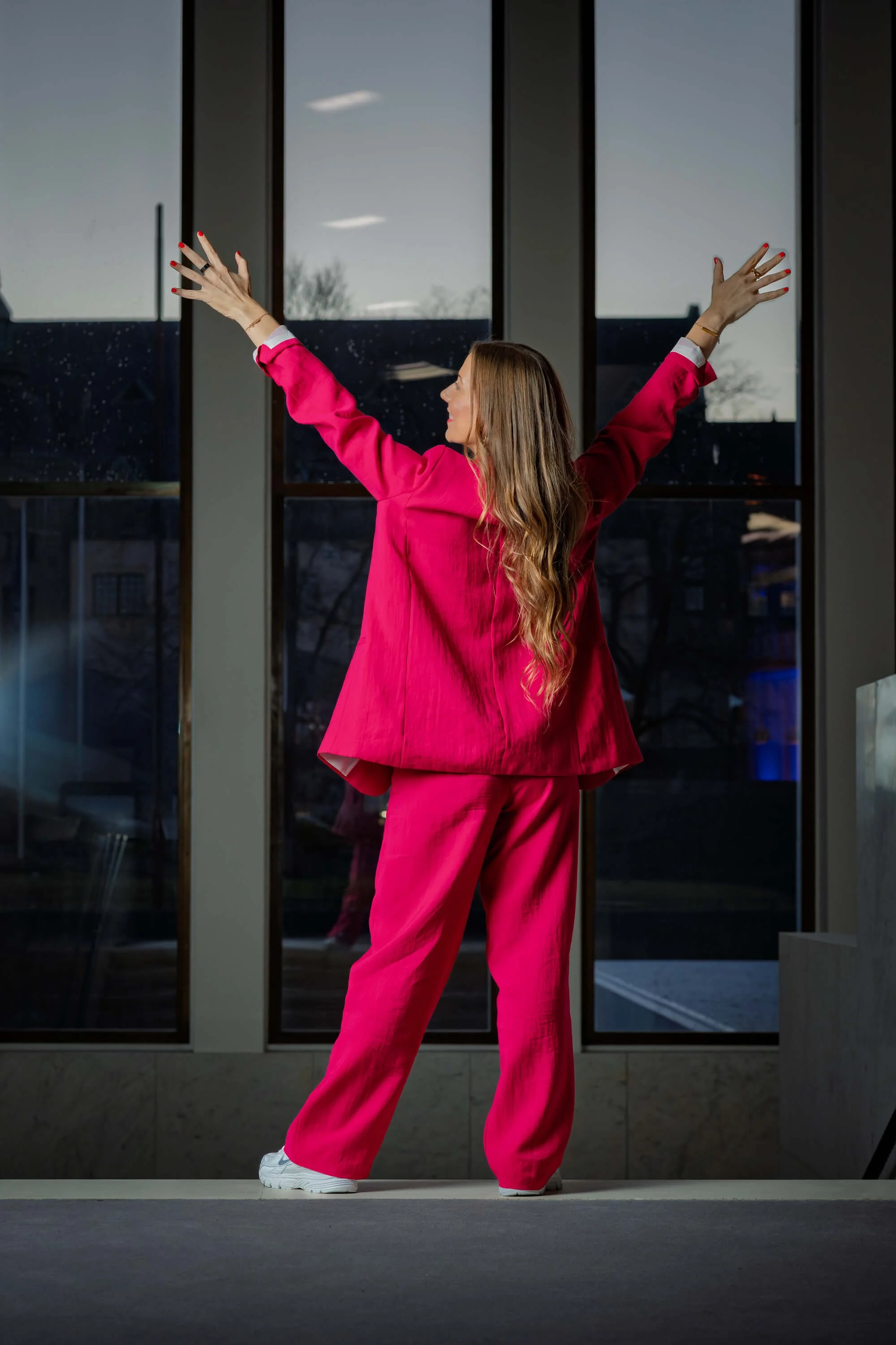 Juontaja poseeraa kädet kohotettuina takaa kuvattuna