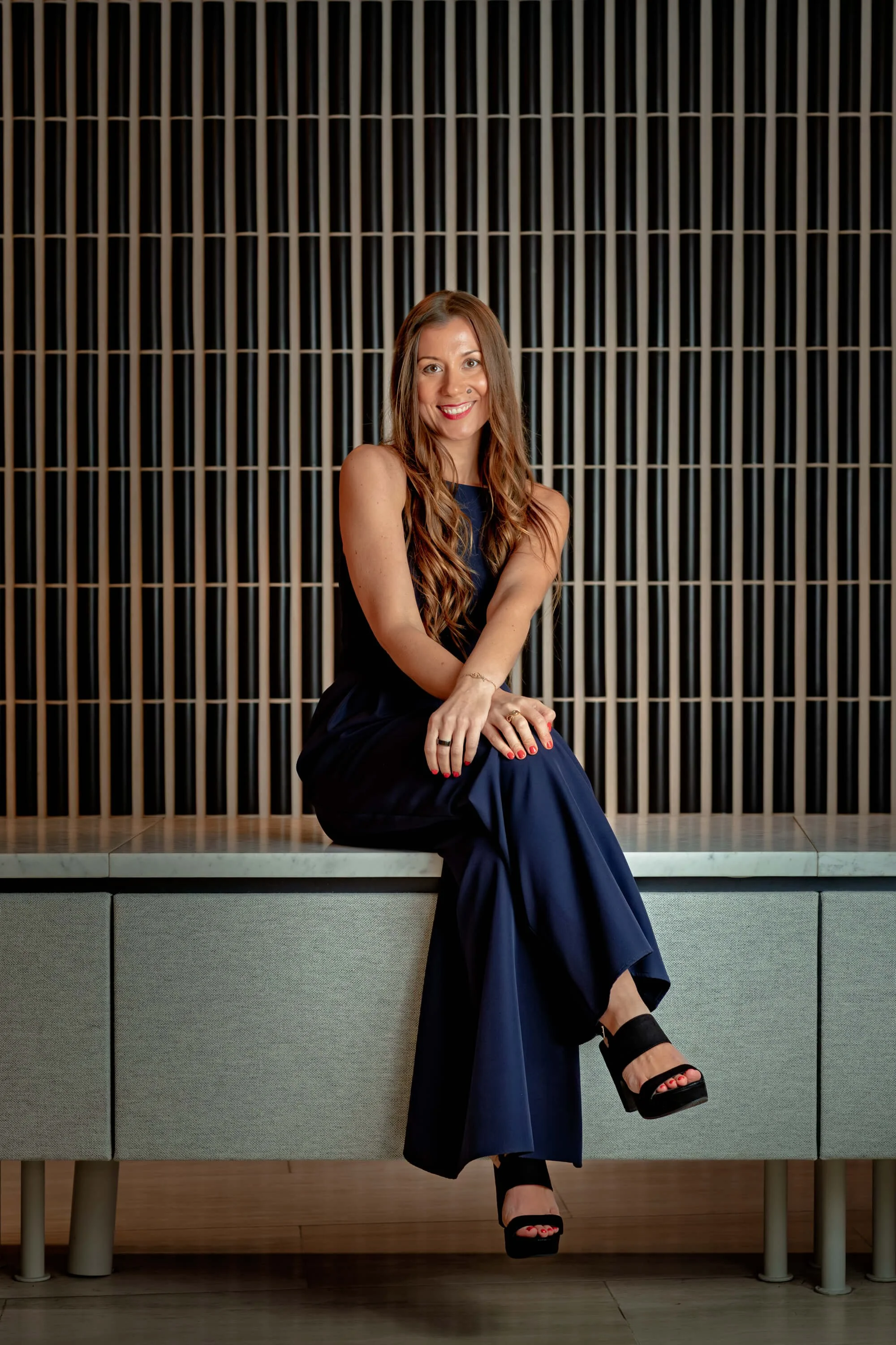 Ammattijuontaja Vilma Tammilehto istuu ja hymyilee