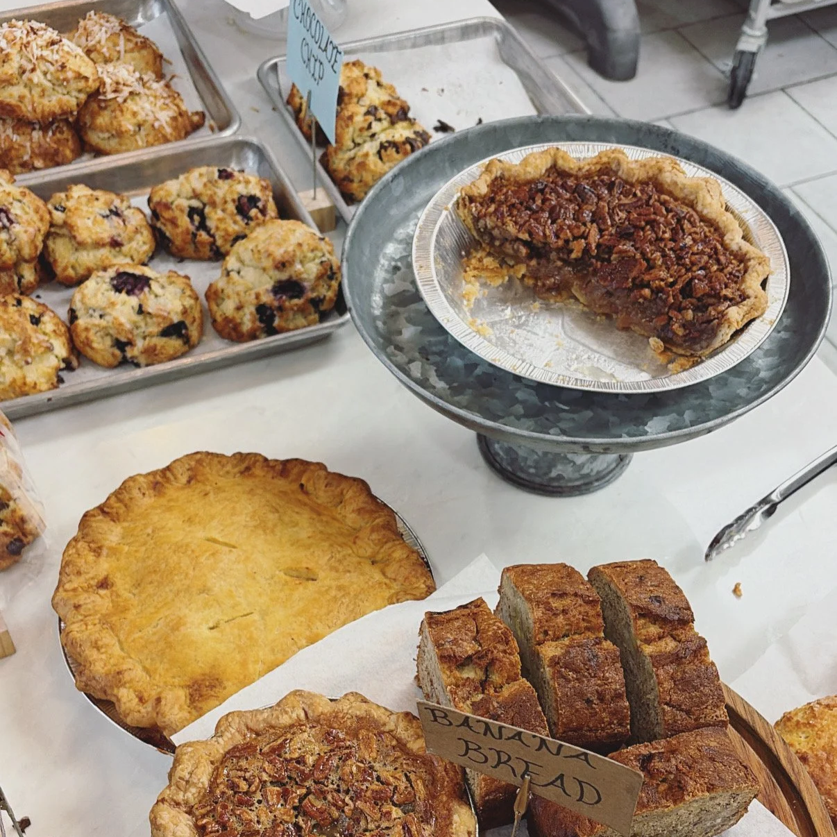 Showcase of a variety of baked goods including pies, banana bread and scones