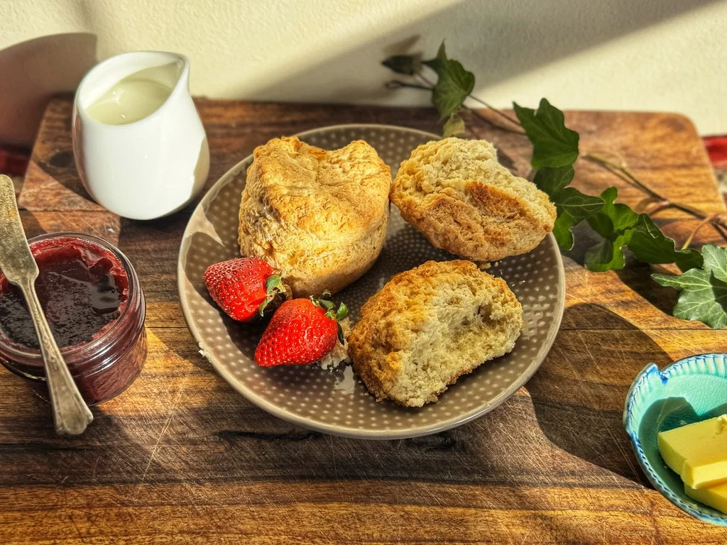 Three scones on a plate with two strawberries