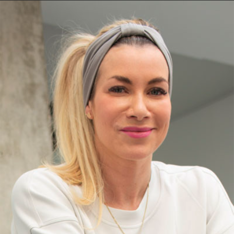 Two women posing together in front of a sign that says 'yupila'. They are making kissy faces and striking playful poses.