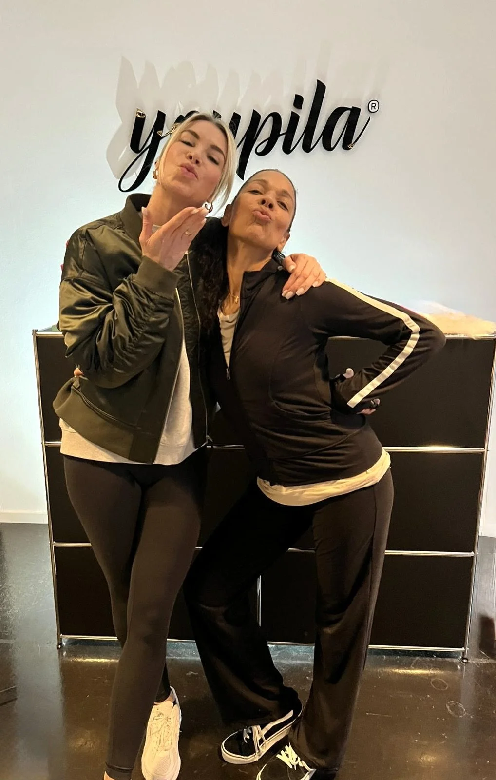 Close-up of a blonde woman with a gray headband smiling at the camera