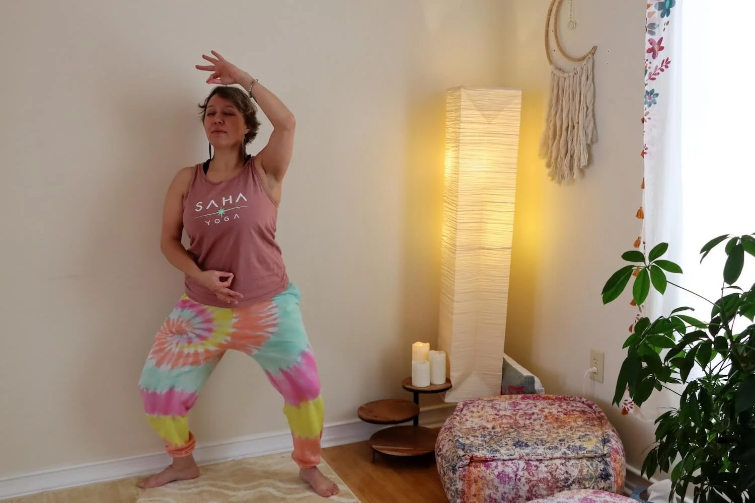 A woman practices a yoga pose in colorful clothing
