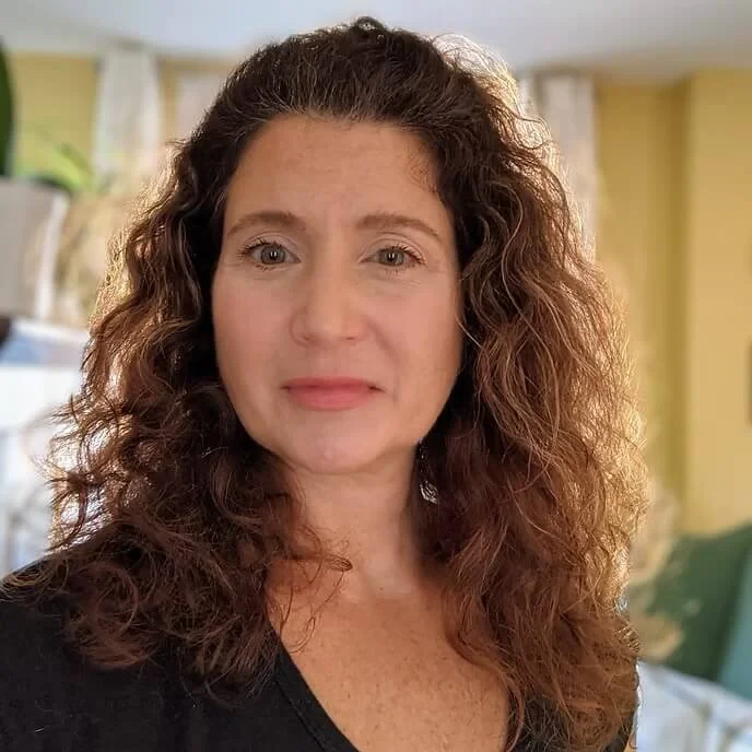 Close up photo of a woman with brown wavy hair