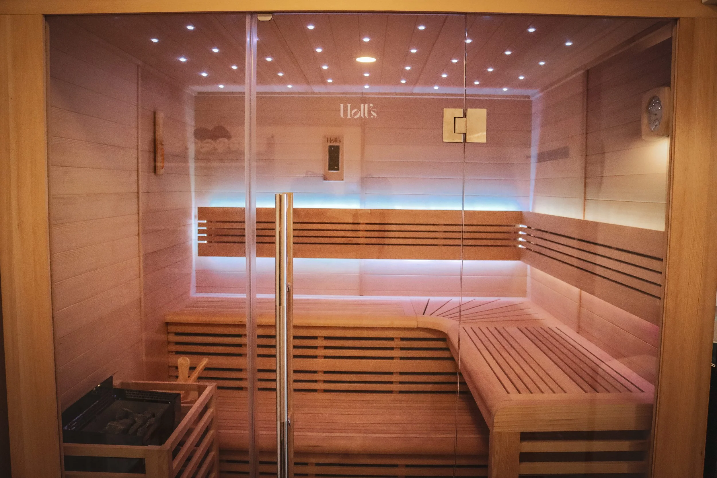 cabine de sauna en bois hemlock avec bancs en bois, murs en bois, porte en verre, éclairage intégré, sauna finlandais, poêle à pierre de lave, bien-être, centre de récupération physique, protocole de récupération, prise en charge individuelle, spa,