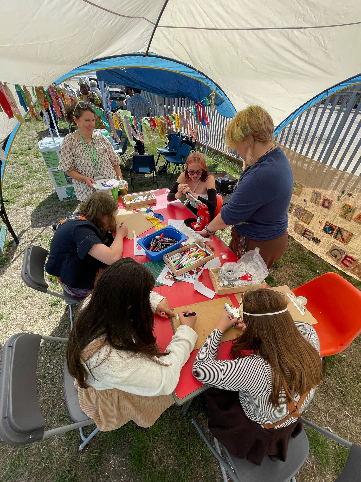 Visitors designing and making their own button badges.