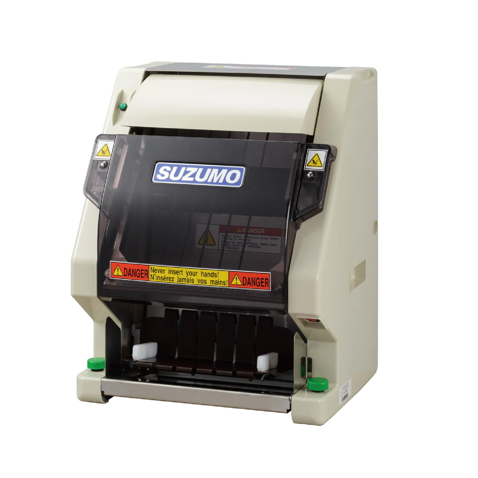 A Suzumo brand conveyor food cutter with warning labels, including a yellow caution sticker and a red danger notice, designed for slicing sushi or similar foods.