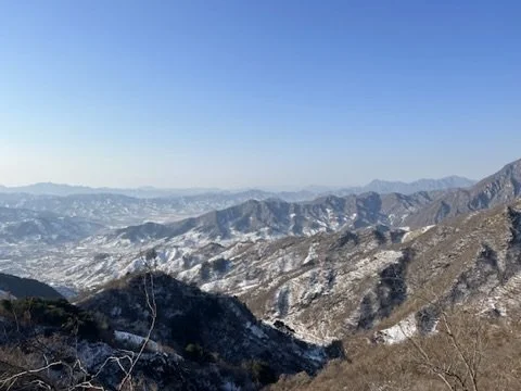Vue panoramique de montagnes enneigées sous un ciel bleu clair.