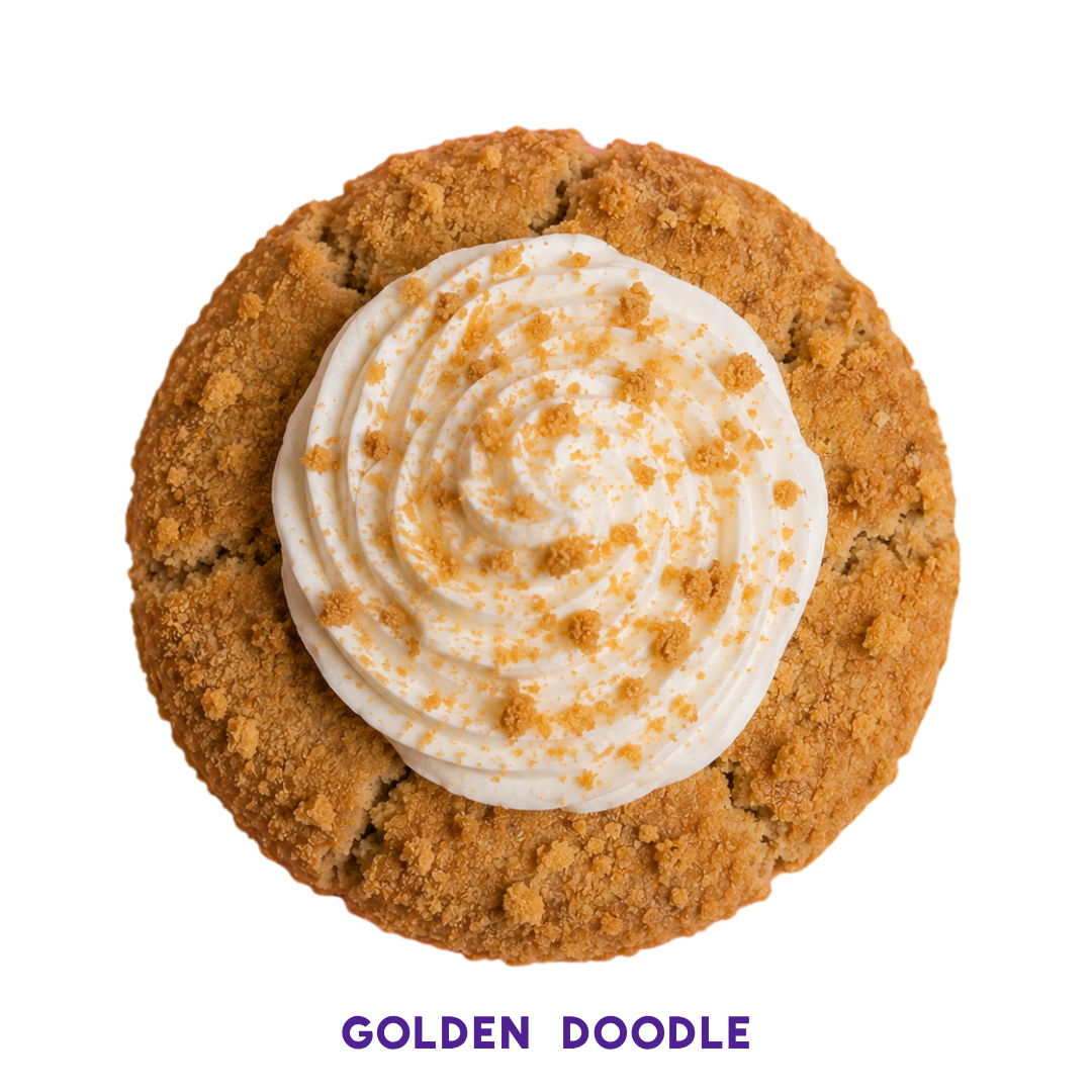 Close-up of a cookie with a crumbly, golden-brown exterior, topped with a dollop of piped whipped cream and sprinkled with crumbled cookie bits.