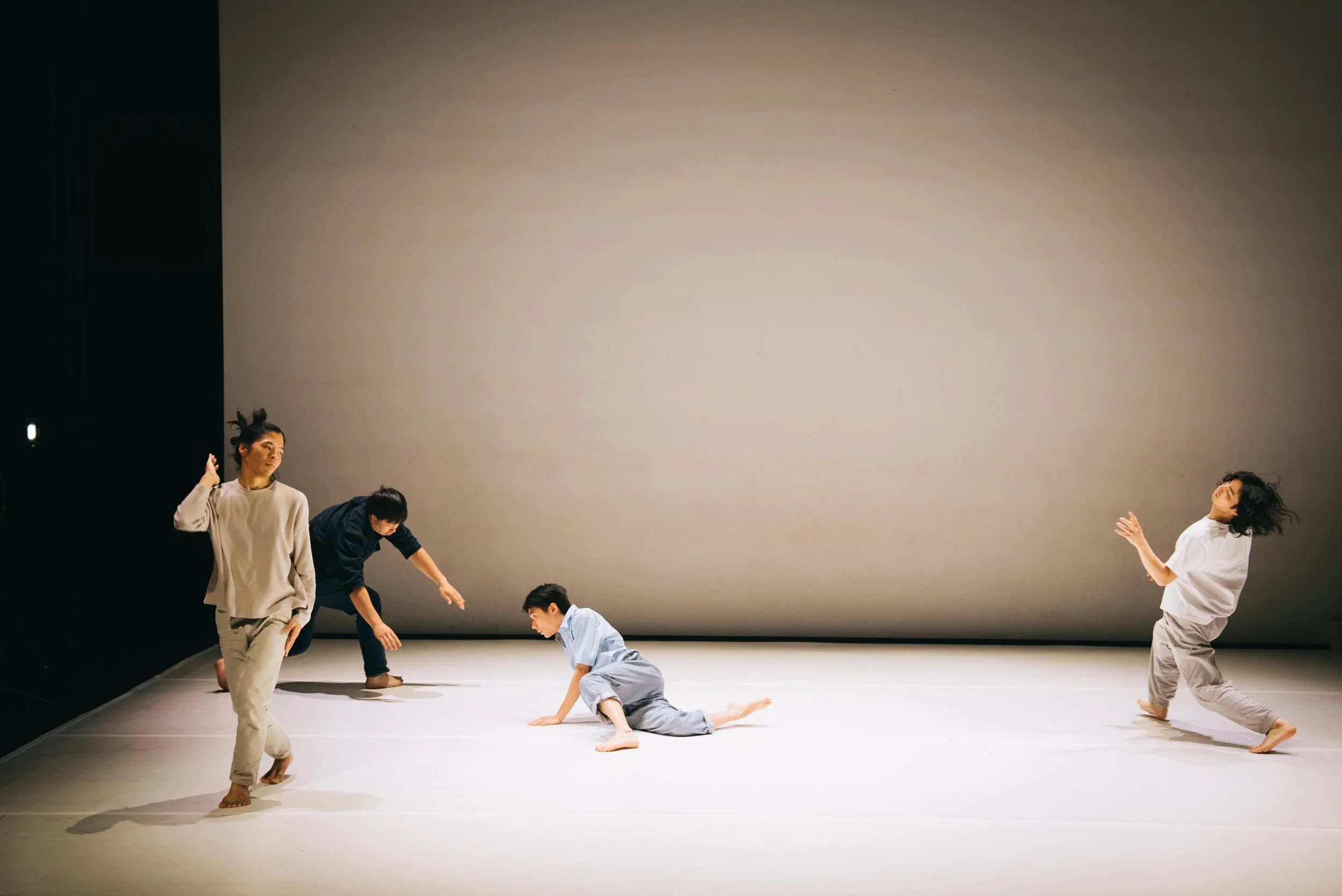 Four dancers improvising together on stage in Total Beings | Burning Hearts.