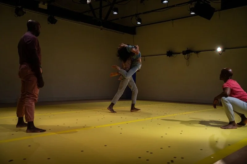 Dancers performing a martial arts–inspired duet on a coin-covered floor in The Righteous Beauty of the Things Never Accounted For.