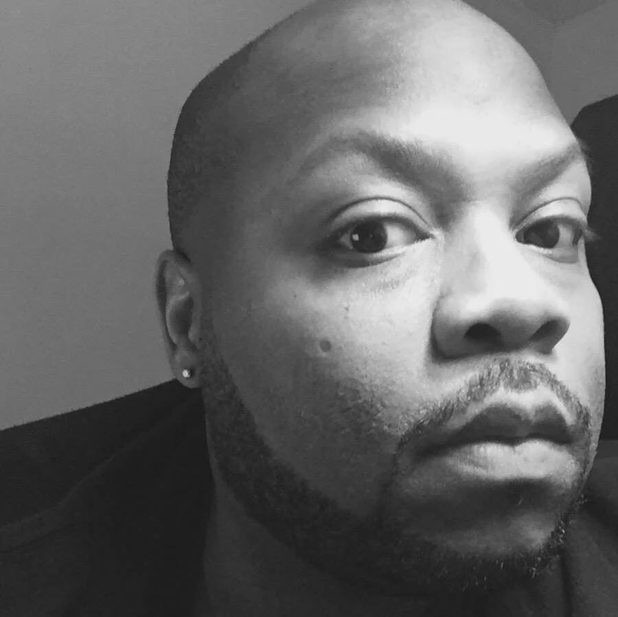 Black and white portrait of Chicago-based dancemaker J’Sun Howard looking directly at the camera, emphasizing presence and intimacy