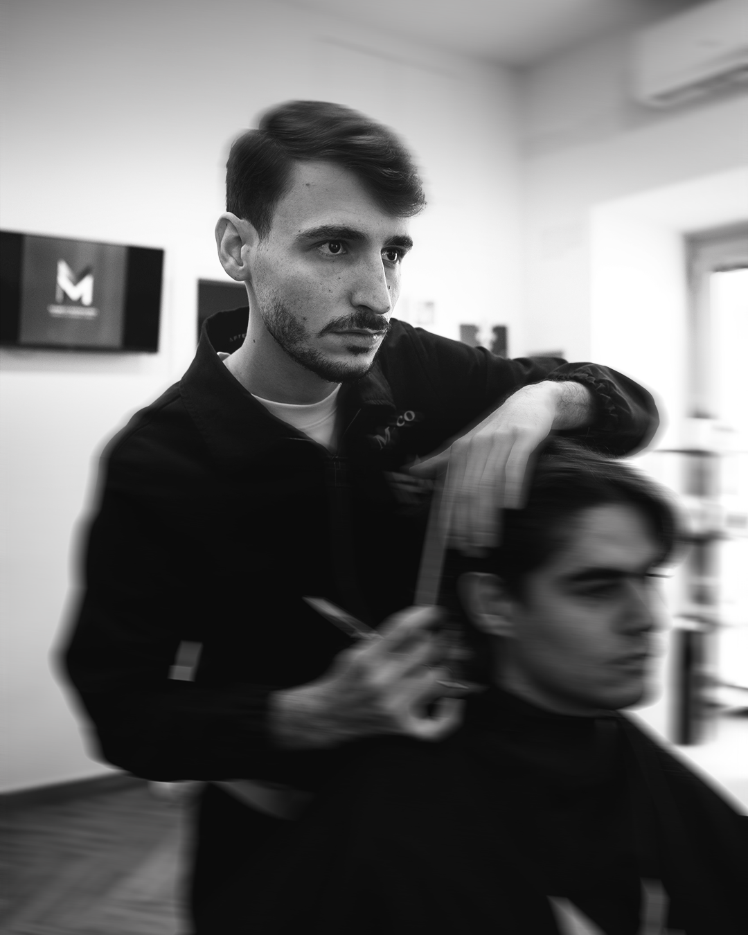 Marco Mangiapia barbiere Pozzuoli taglia i capelli a un cliente nel suo salone