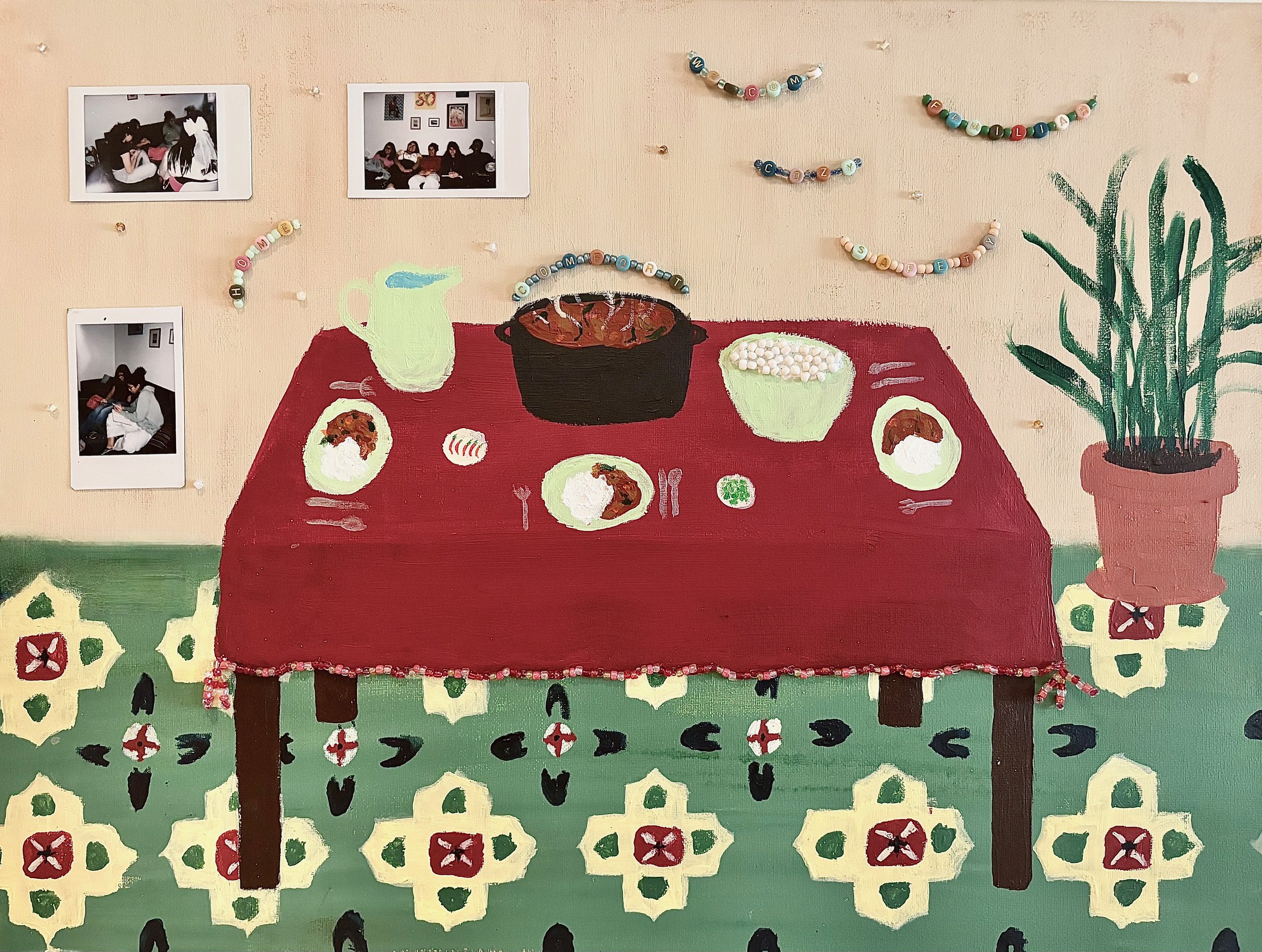A wall painting of a dining table with a red tablecloth, bowls of food, a pitcher, and utensils. Decorated with colorful beaded garlands and a potted plant in a clay pot. Photographs of people are hanging on the beige wall above the table.