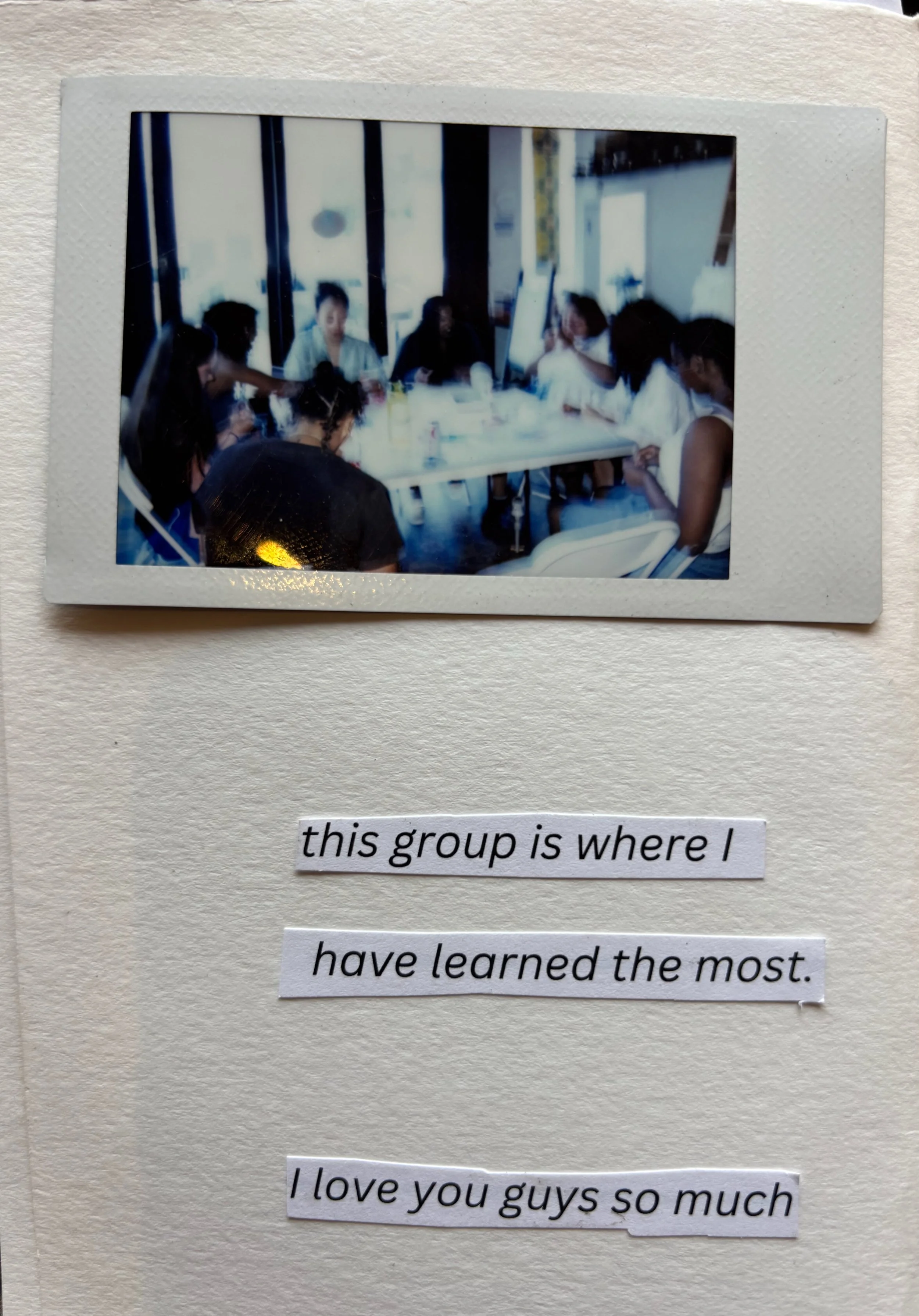 A group of people sitting around a table in a bright room, some using their phones, with a caption underneath that says, "this group is where I have learned the most. I love you guys so much."
