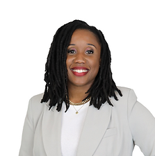 Portrait of a woman with dark curly hair wearing a white blazer and a gold necklace, smiling against a white background.