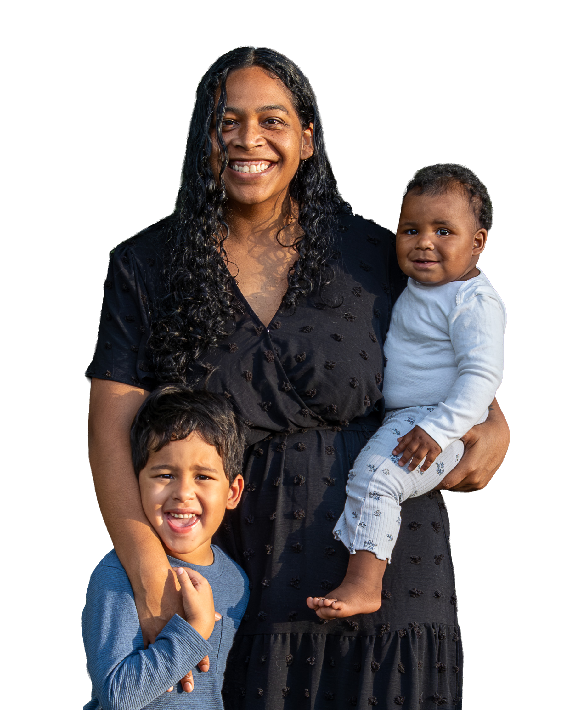 A woman smiling with two young children, one boy and one girl, outdoors.