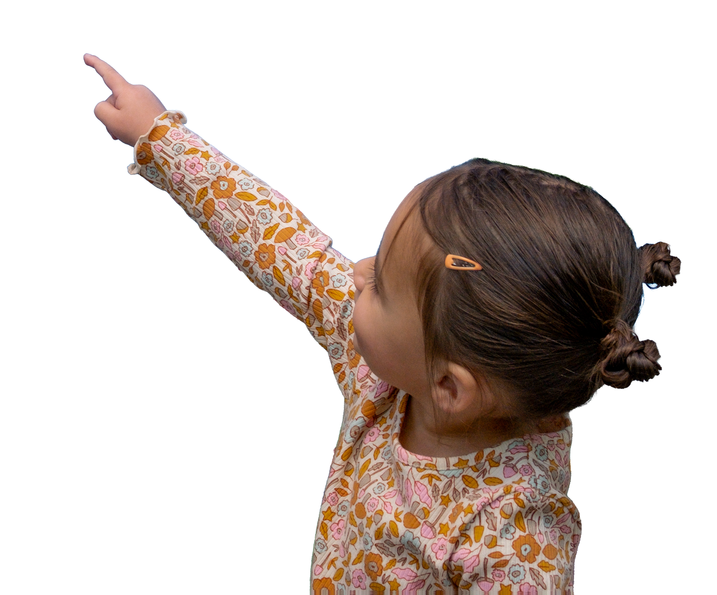 A young girl with brown hair in pigtails, wearing a floral long-sleeve shirt, points upward with her right arm extended.