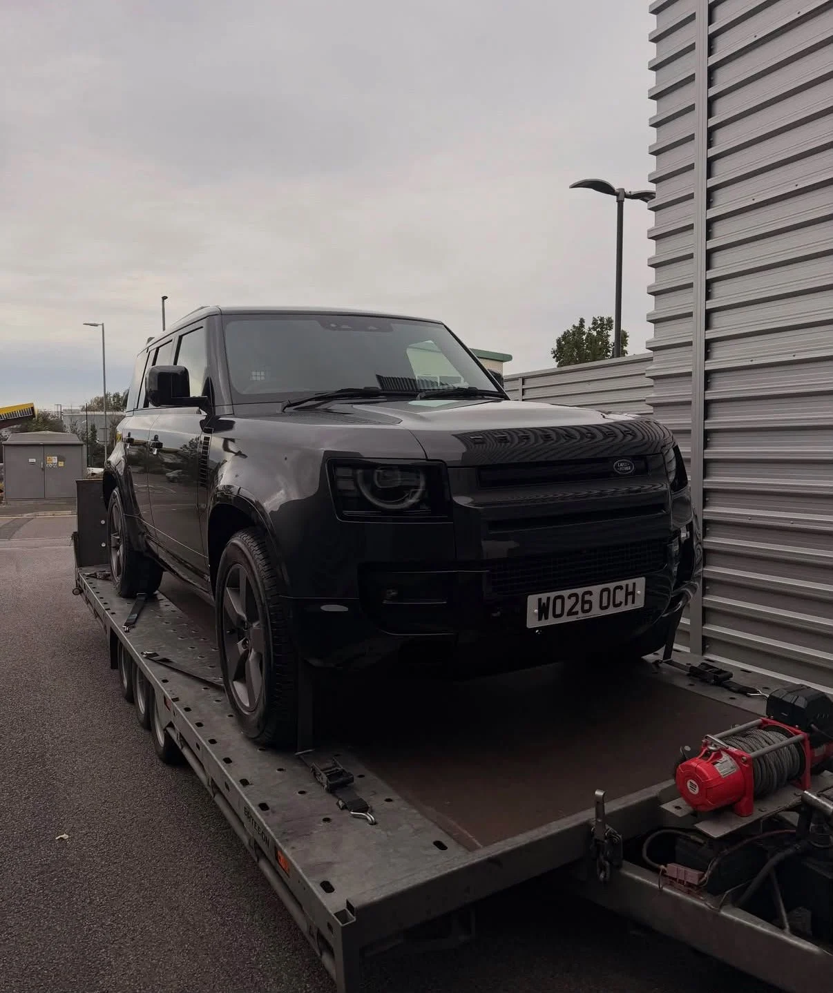 Black Land Rover Discovery SUV on a flatbed tow truck