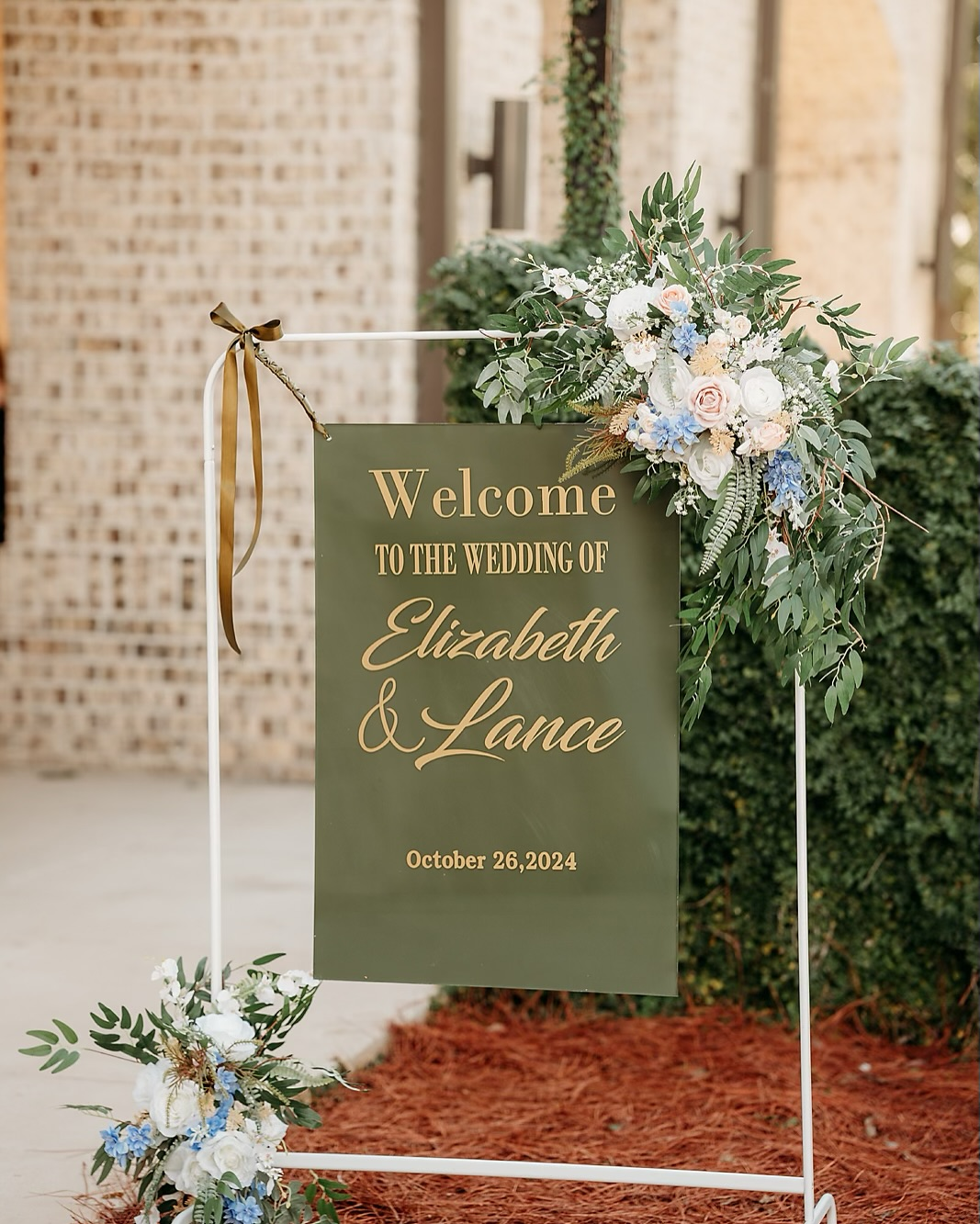 Wedding welcome sign with floral decorations, greeting guests for Elizabeth and Lance's wedding on October 26, 2024.