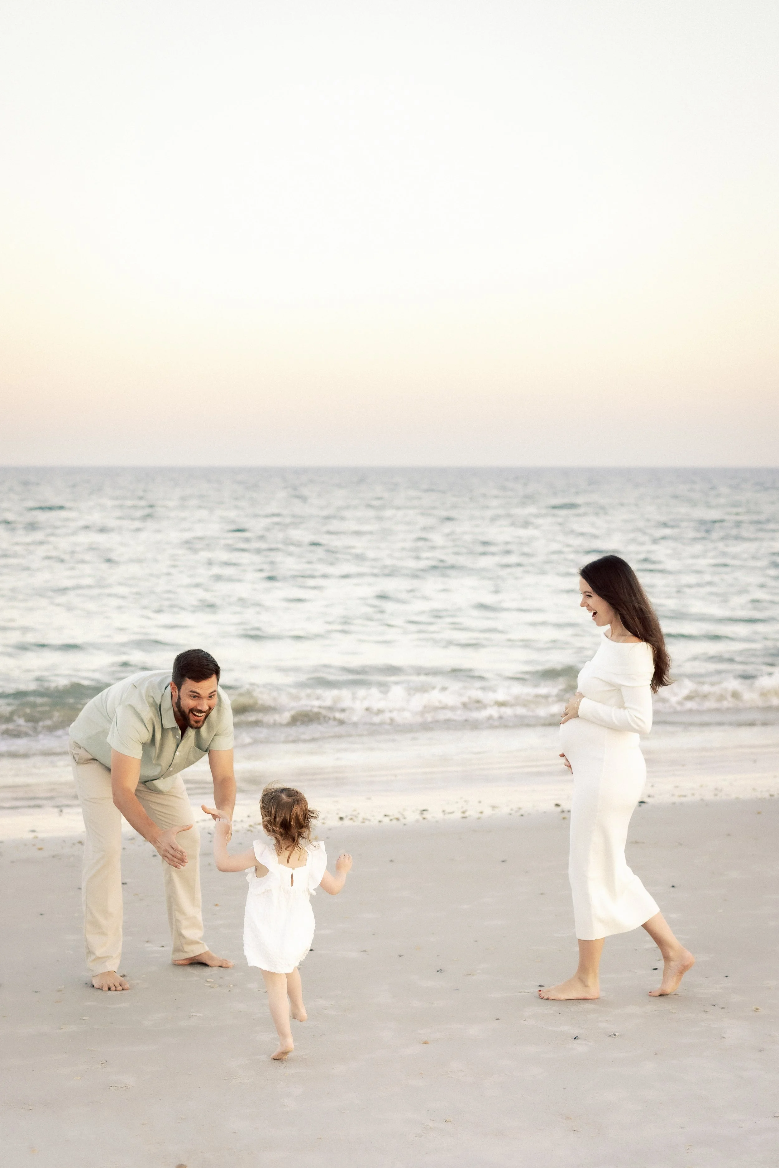 A family playing on the beach, a father, mother, and two young children, with mountains in the background.Photographer Amelia Island, Jacksonville, St Augustine, St Simons Island, Savannah photographer