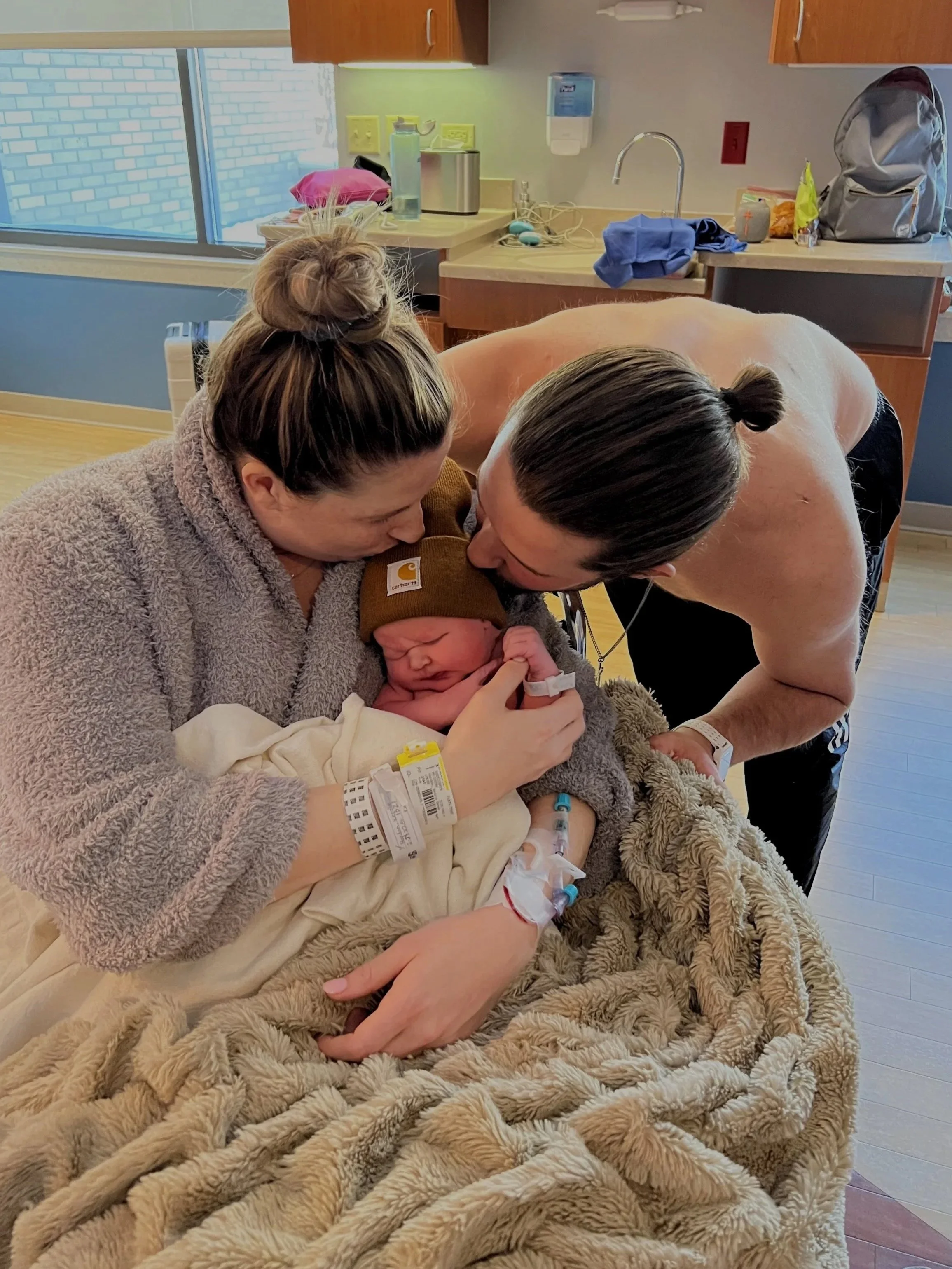 mom and dad with baby post birth