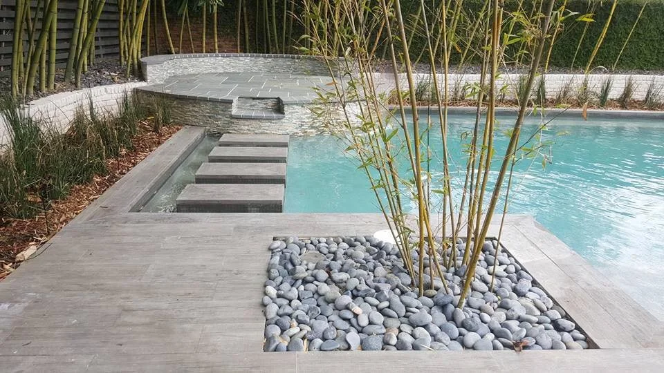 Custom-designed geometric residential pool with tanning ledge and hot tub in Baton Rouge built by Gulf South Pools & Outdoors.