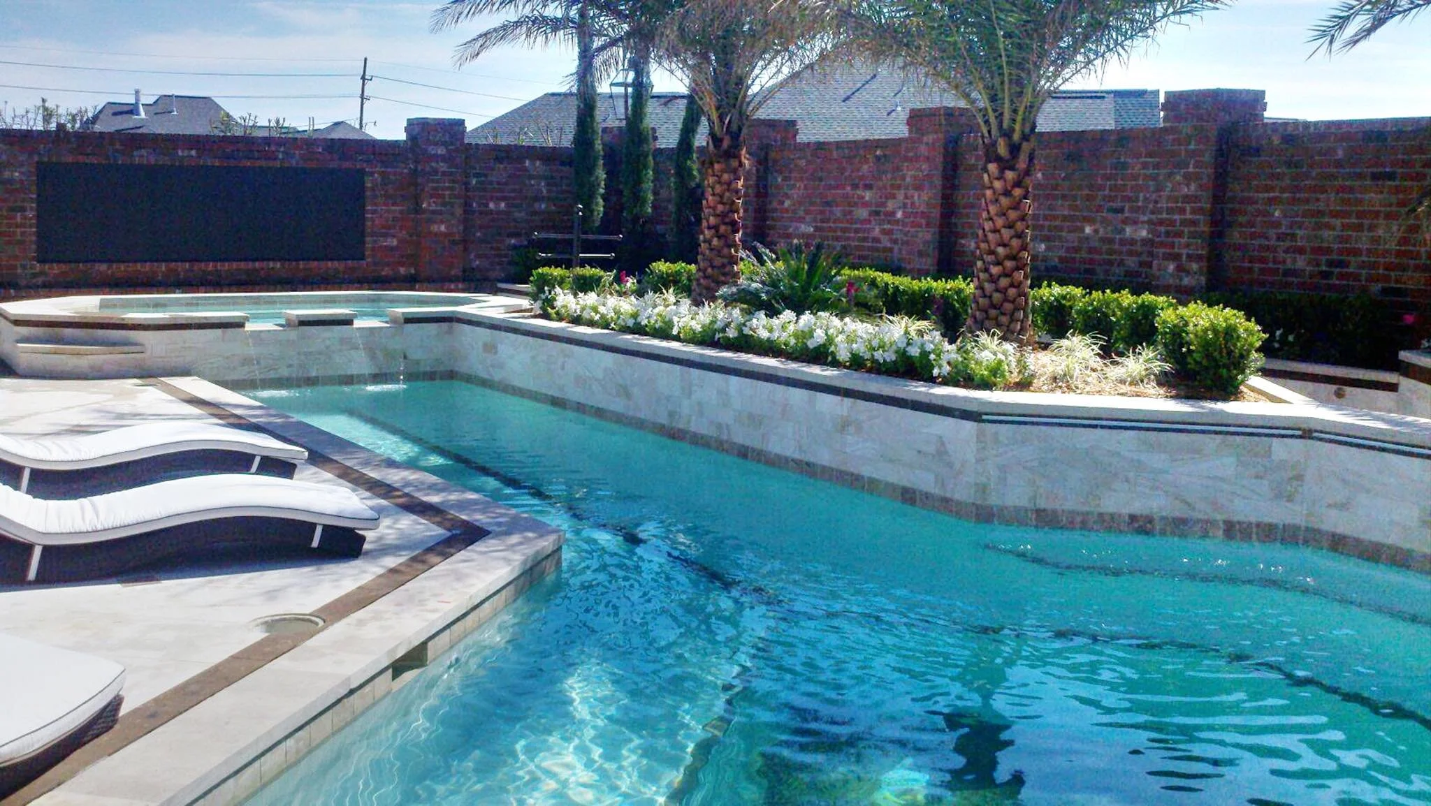 Custom-designed geometric residential pool with waterfall and hot tub in Baton Rouge built by Gulf South Pools & Outdoors.