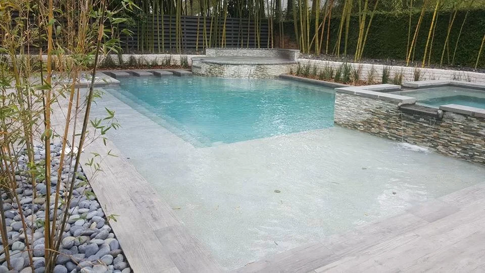 Custom-designed geometric residential pool with tanning ledge and hot tub in Baton Rouge built by Gulf South Pools & Outdoors.