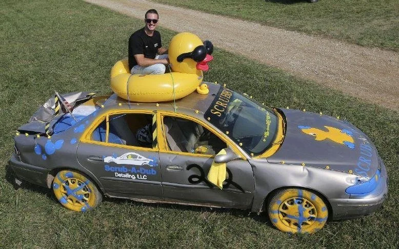 Dilan Pagrabs sitting on top of a decorated car with a duck-shaped float on the roof.