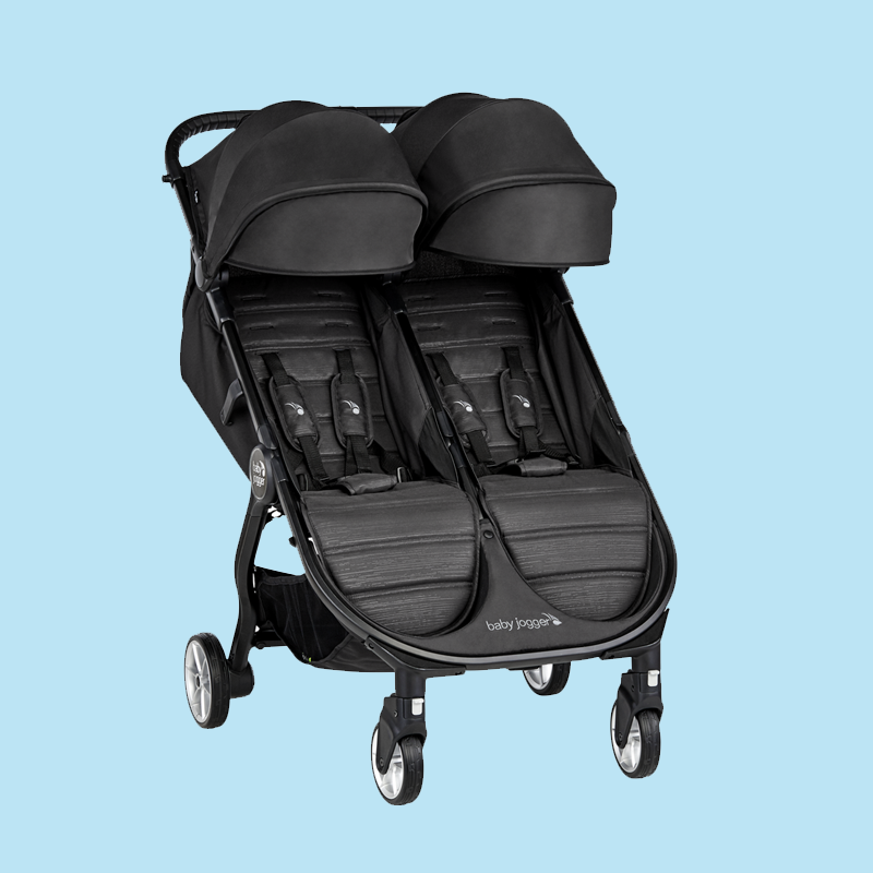 A black double stroller with two seats and canopies against a blue background.