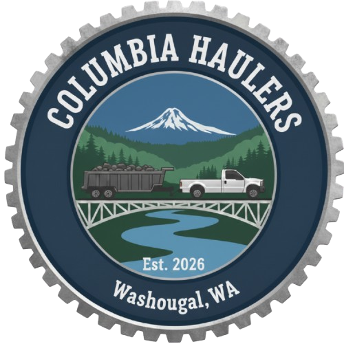 A circular emblem with the words 'Columbia Haulers' at the top and 'Washougal, WA' at the bottom, with a mountain, river, bridge, truck hauling logs, and a white pickup truck in the center, and 'Est. 2026' at the bottom.