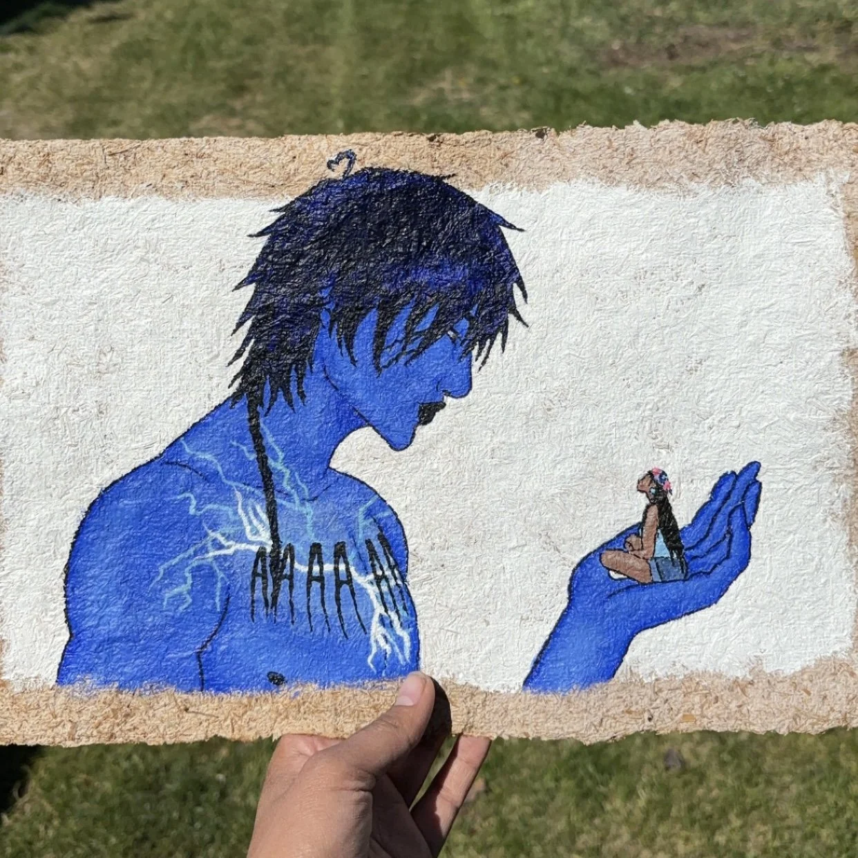 A person holding a piece of artwork depicting a blue-skinned man with black hair. The man has lightning on his body and is looking at a tiny woman on his palm, who is wearing a bikini top, shorts, and a floral headband.