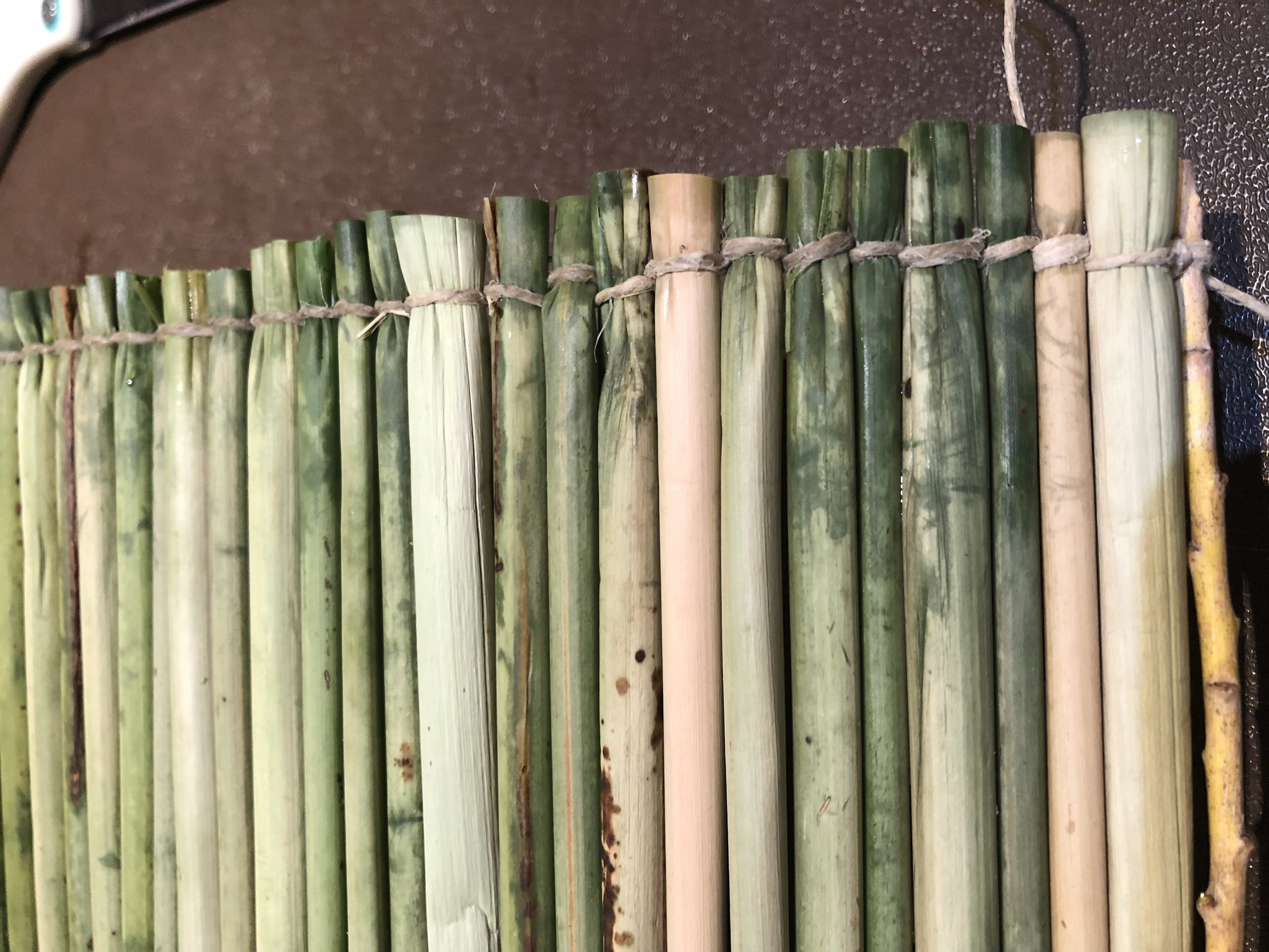 Close-up of a traditional bamboo mat with horizontal bamboo slats tied together with string.