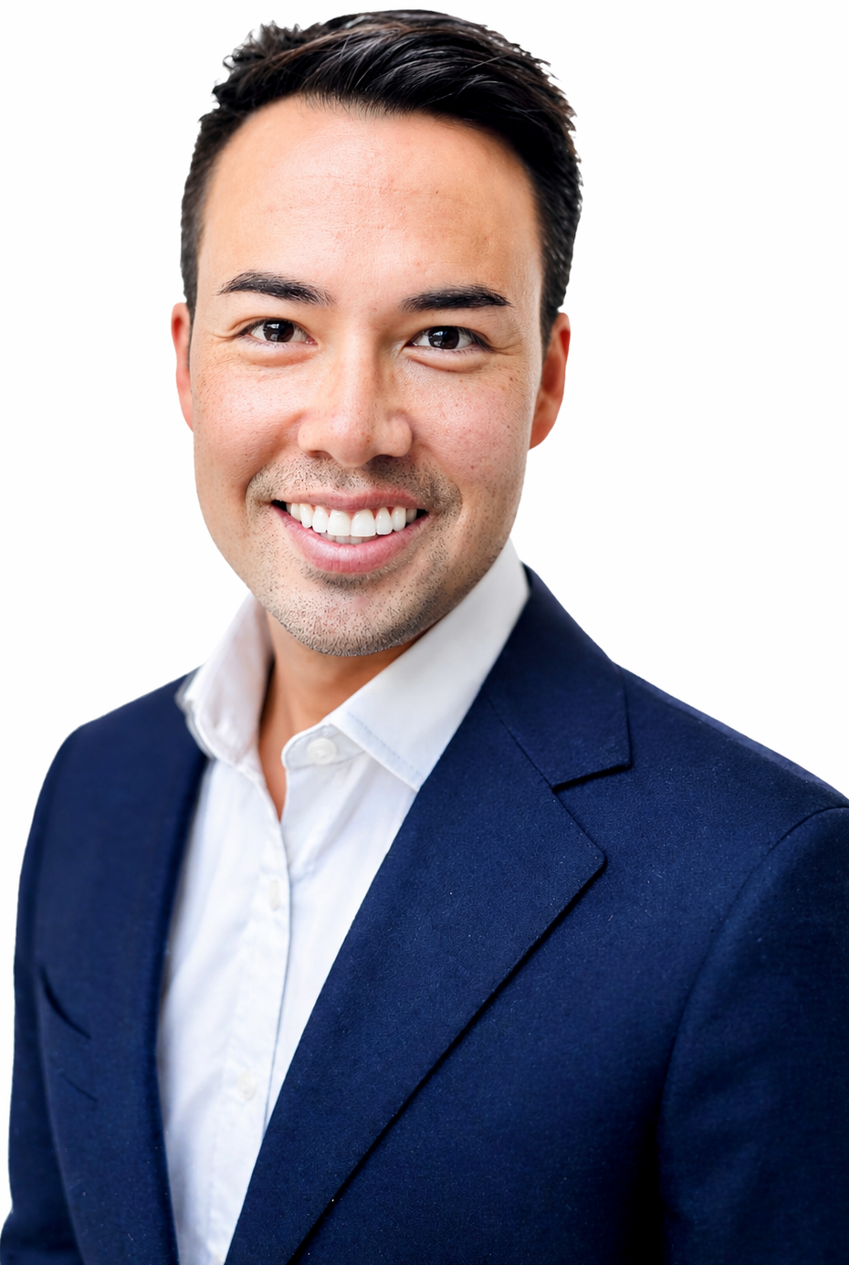 Headshot of a smiling man with dark hair, wearing a white shirt and navy blazer, against a white background.