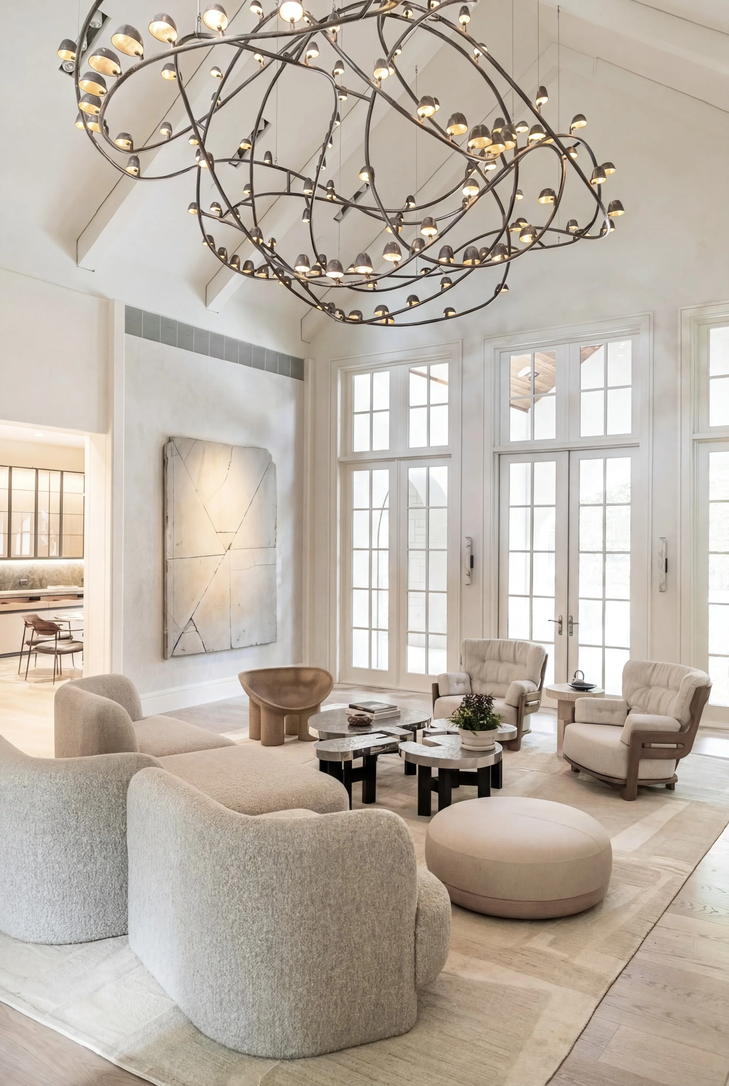 Double-height living room with monumental custom bronze Molenschot chandelier, oversized artwork, and sculptural furnishings in a modern estate home.
