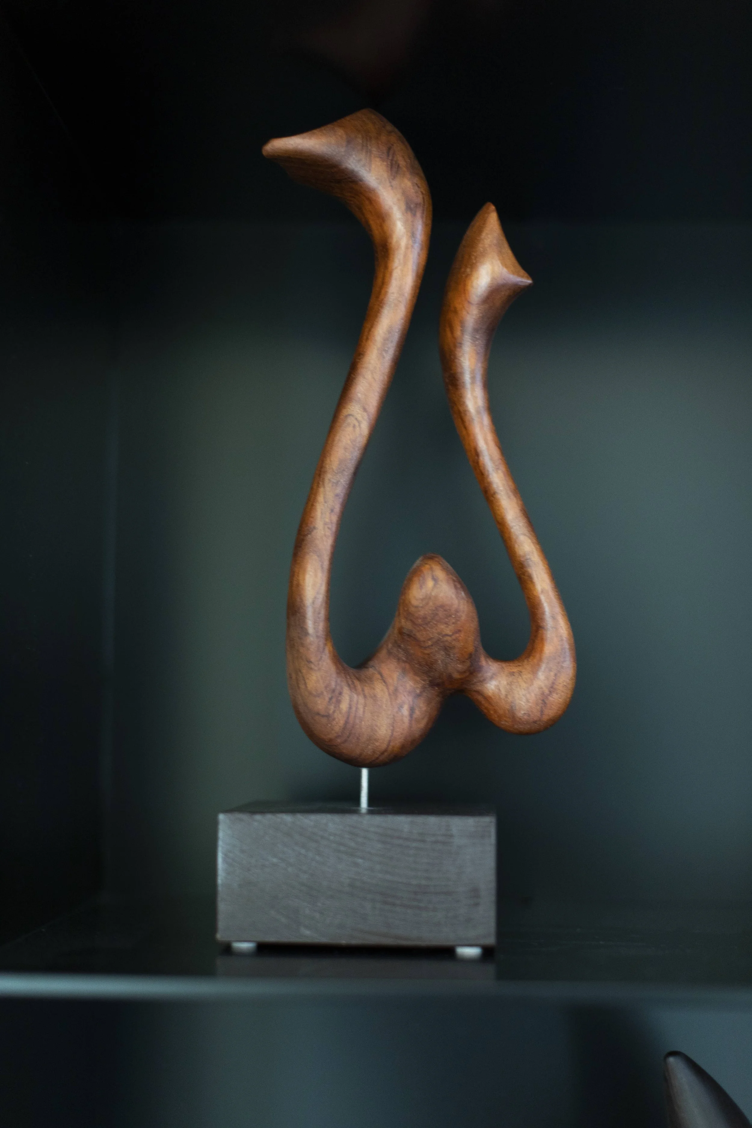 Abstract carved wood sculpture displayed in custom shelving within modern luxury interior.  Japanese sculptor Teruo Kinoshita