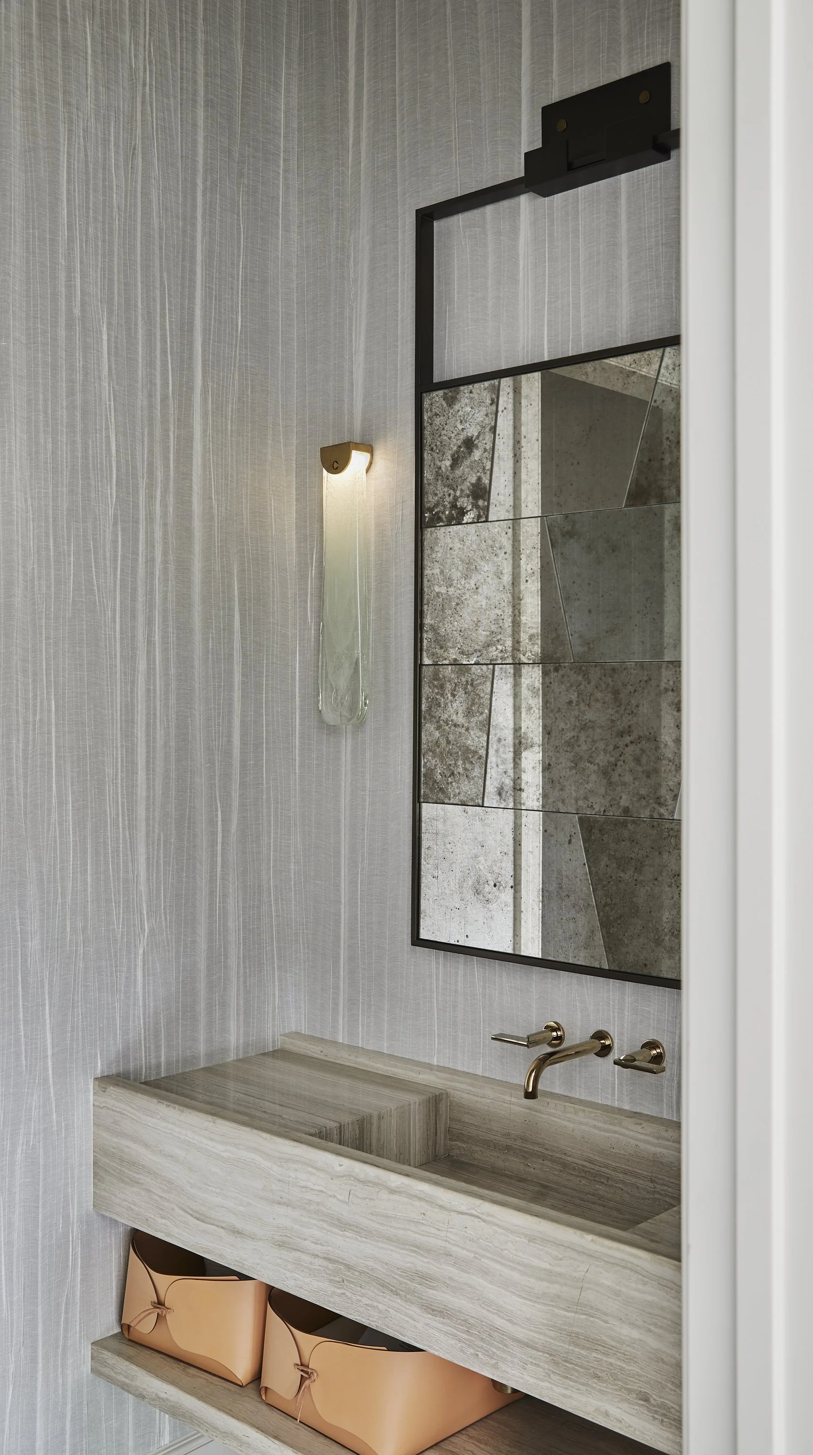 Minimalist powder room with textural wallpaper and nublado stone sink.  Articolo sconces