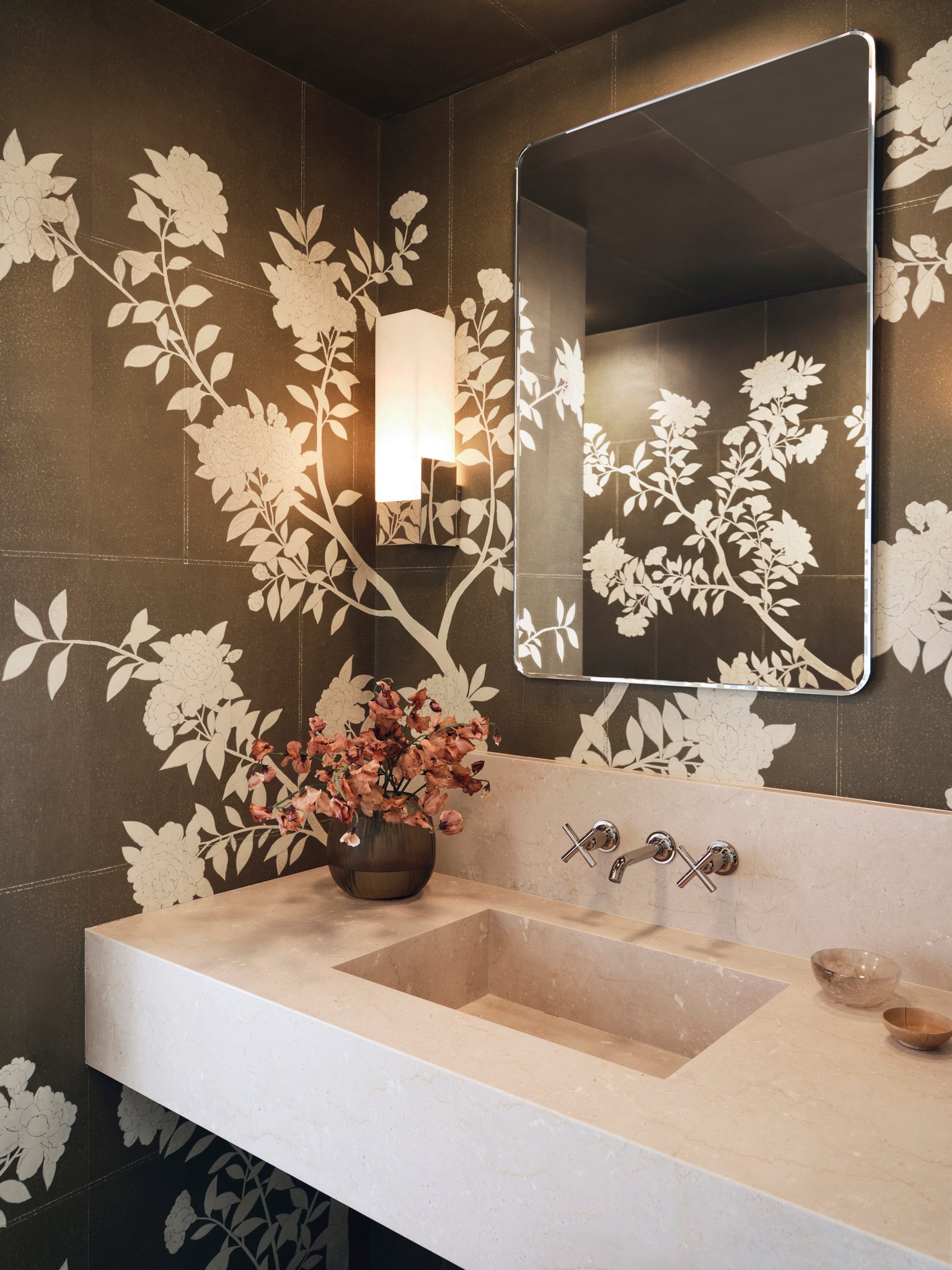 Luxury powder room with stone vanity, wall-mounted faucet, and hand-painted Gracie floral patterned wallpaper, combining refined materials and contemporary detailing.