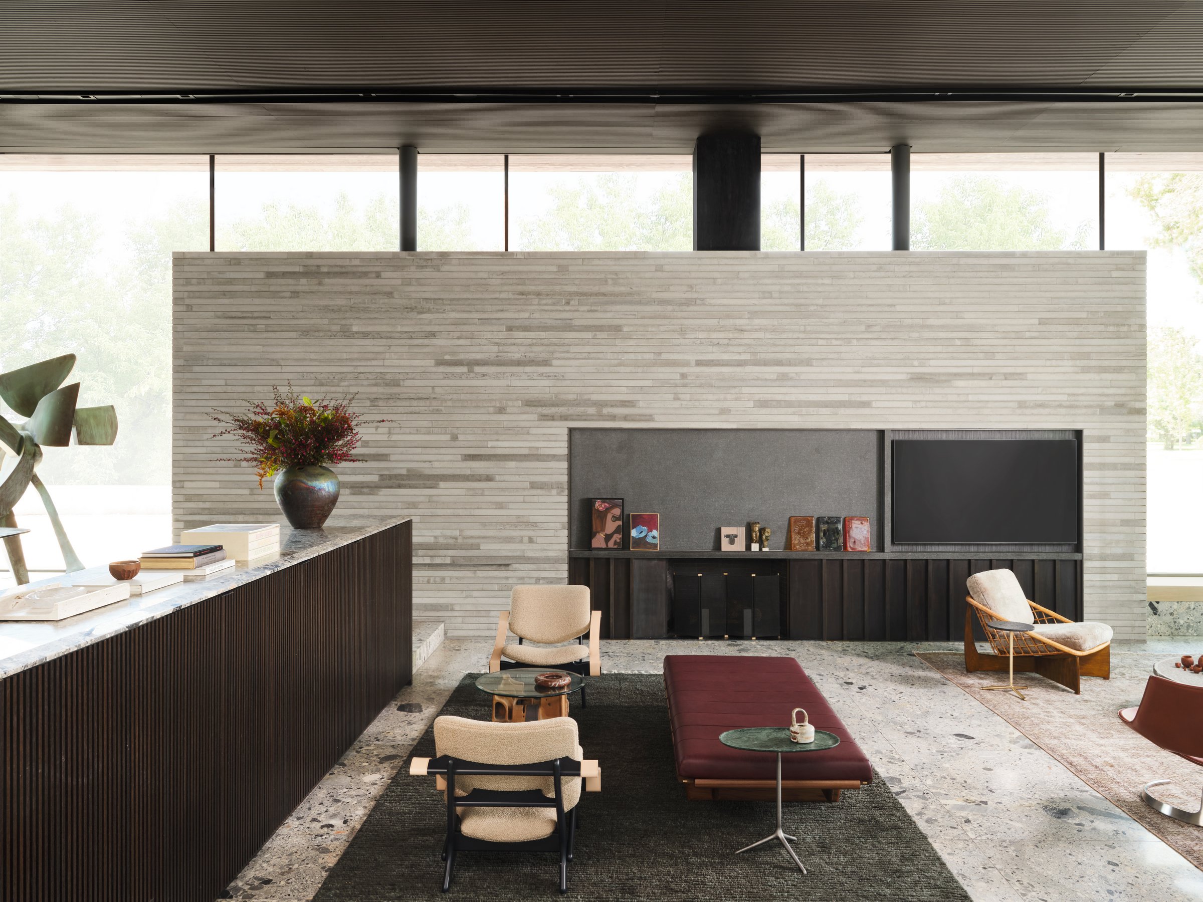 Living area with integrated fireplace wall and low-slung seating, balancing massing, texture, and curated furnishings. Oxblood Leather and Walnut “BLR” daybed designed by Joshua Rice
Green Marble Side Table by Jader Almeida
Vintage Jumbo chairs Olof 