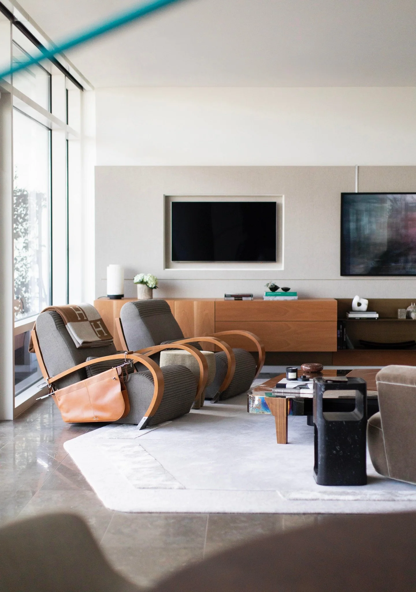 Luxury modern living room with sculptural lounge chairs, large windows, custom wood cabinetry, and contemporary art.  Jaime tresserra, vincenzo de cotiis,  christian astuguevieille michael verheyden porro jeff miller baleri italia