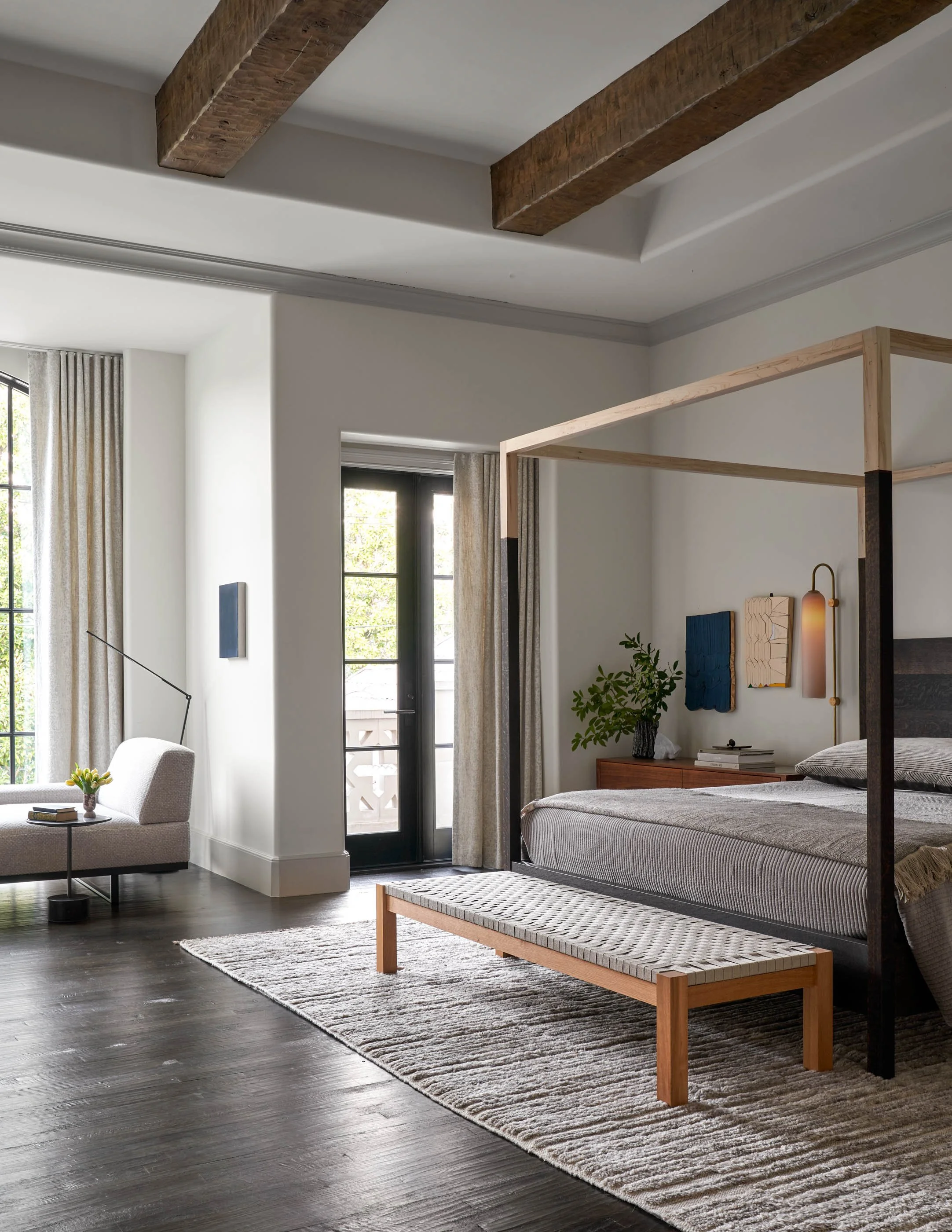 Calm and warm modern bedroom with canopy bed, exposed wood beams, and minimalist contemporary furnishings BDDW